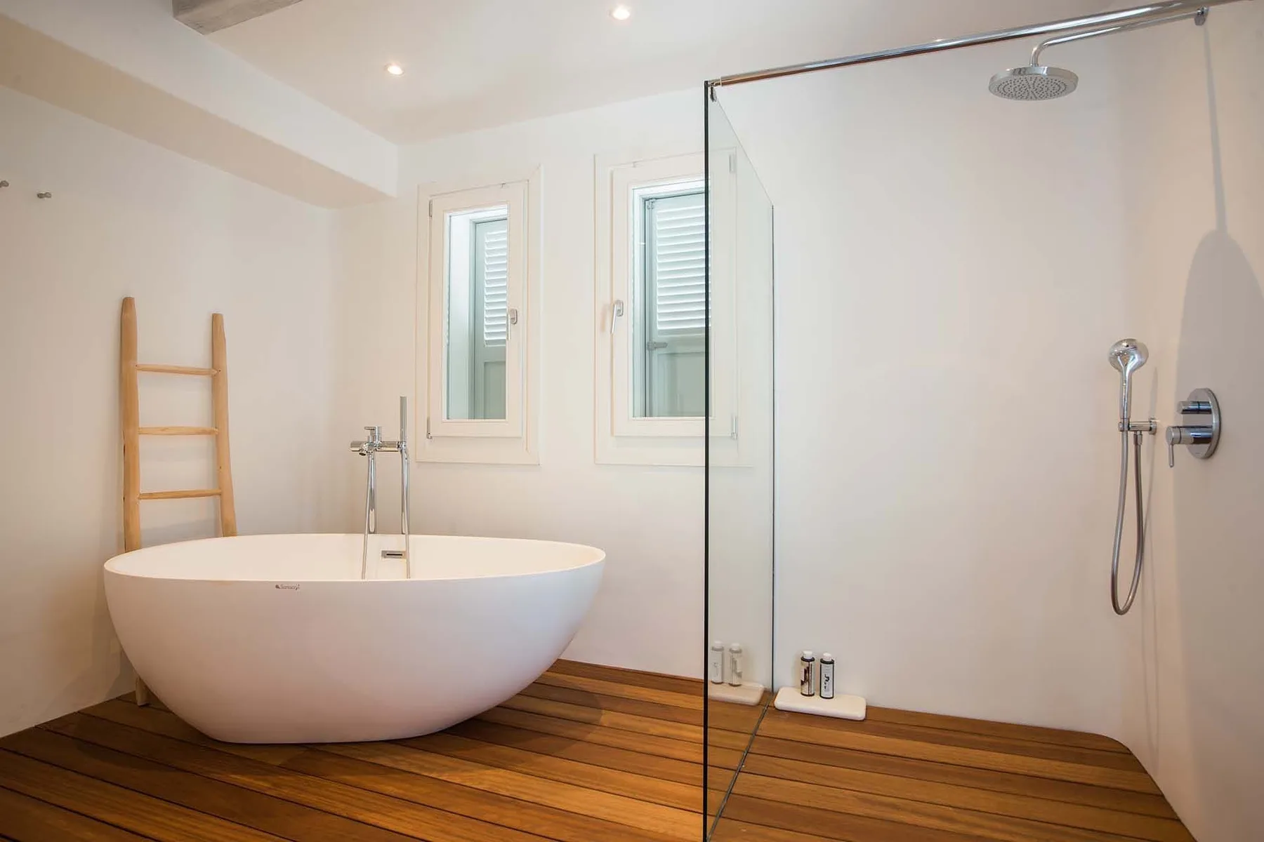 A bright bathroom with a freestanding bathtub and a glass shower.