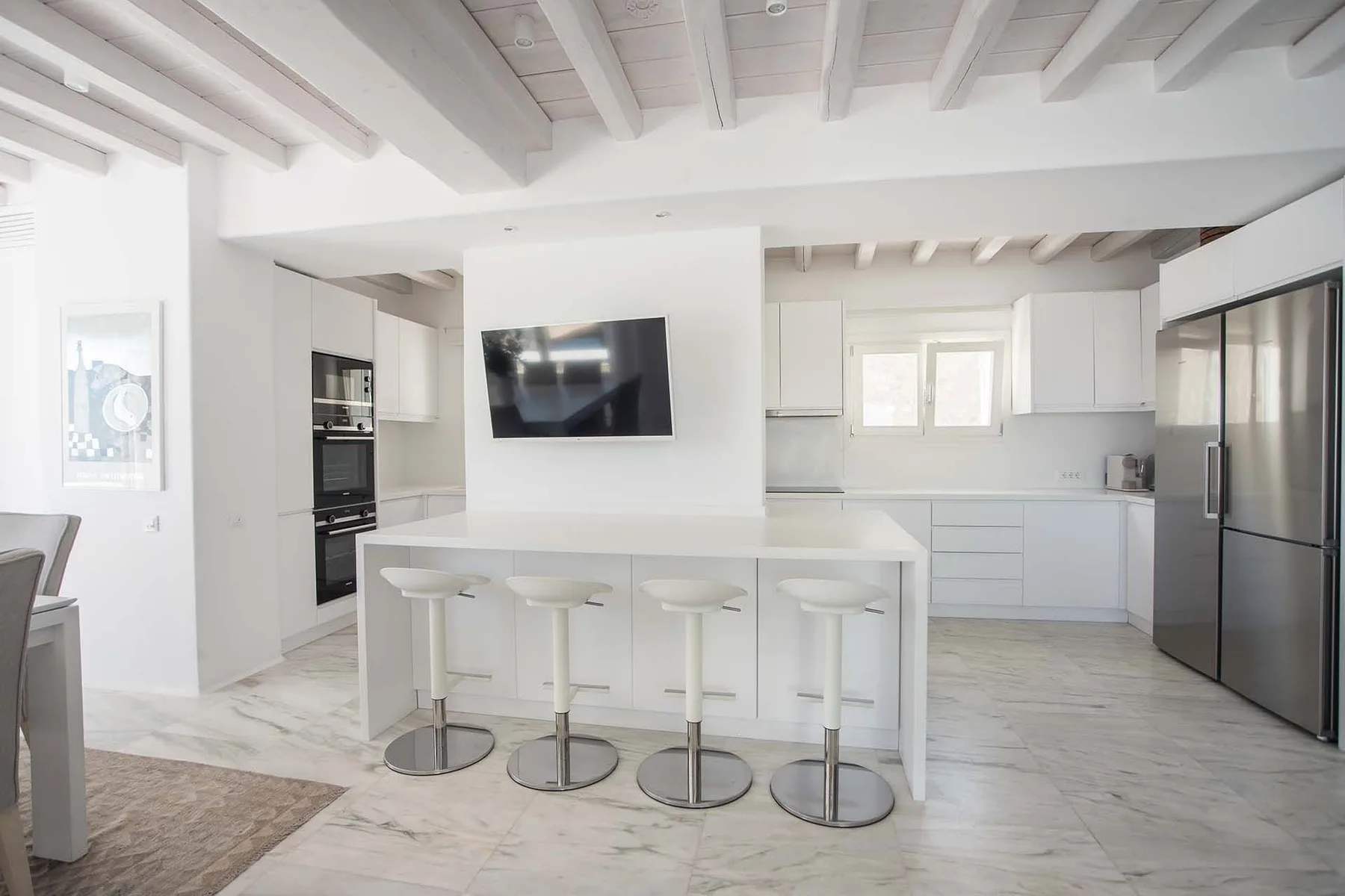 A bright modern kitchen with an island and built-in appliances.