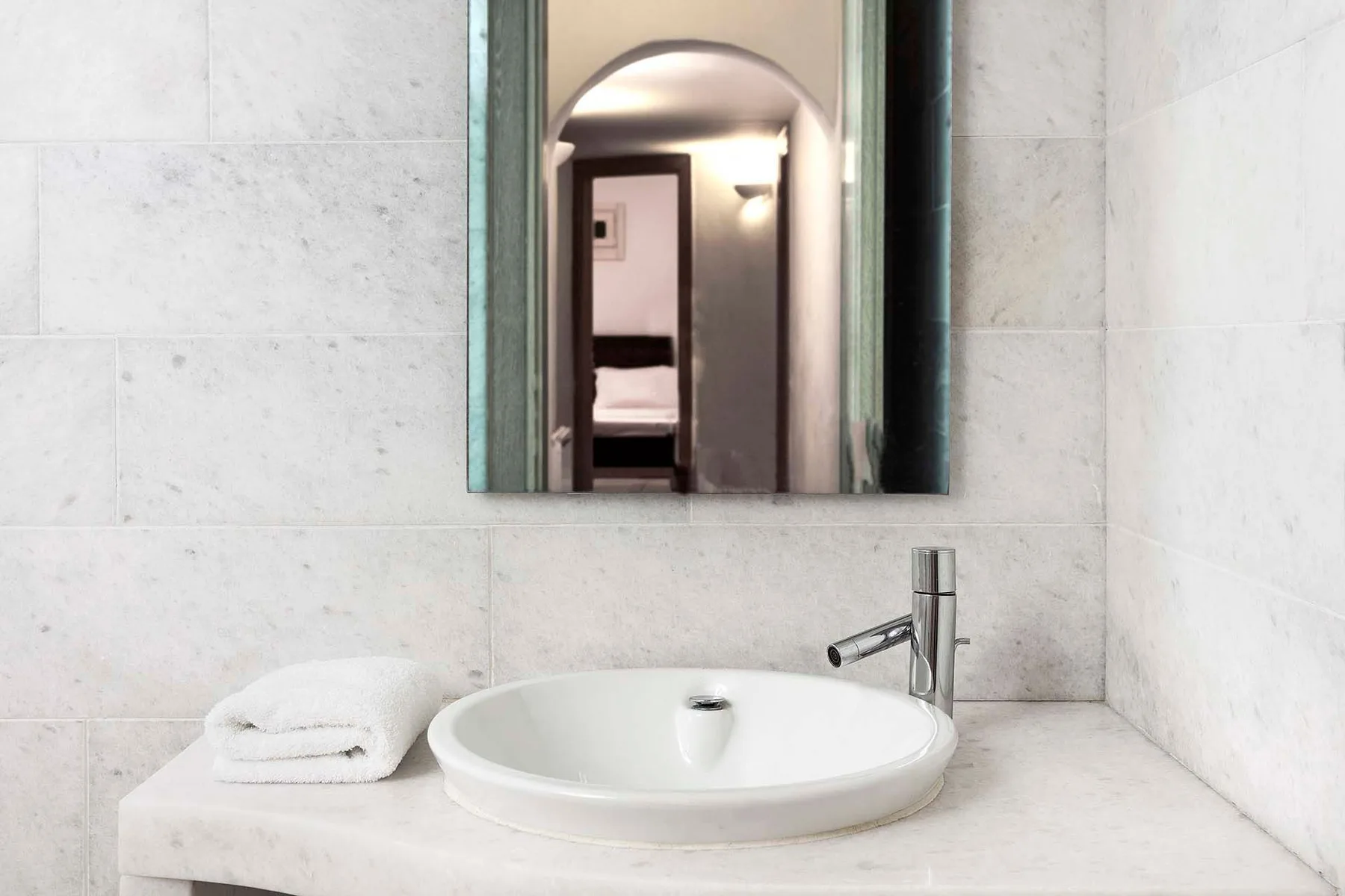 A bathroom vanity with a white basin and a mirror above it.