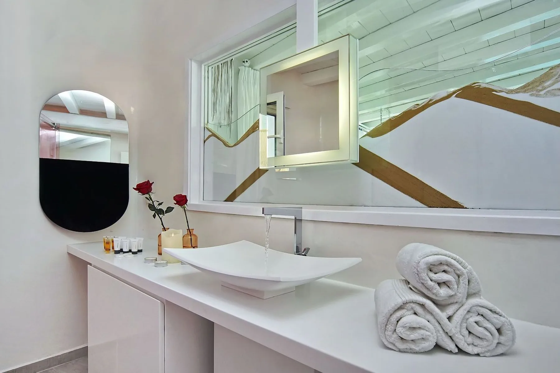 A bright bathroom vanity features a vessel sink and a large wall mirror.