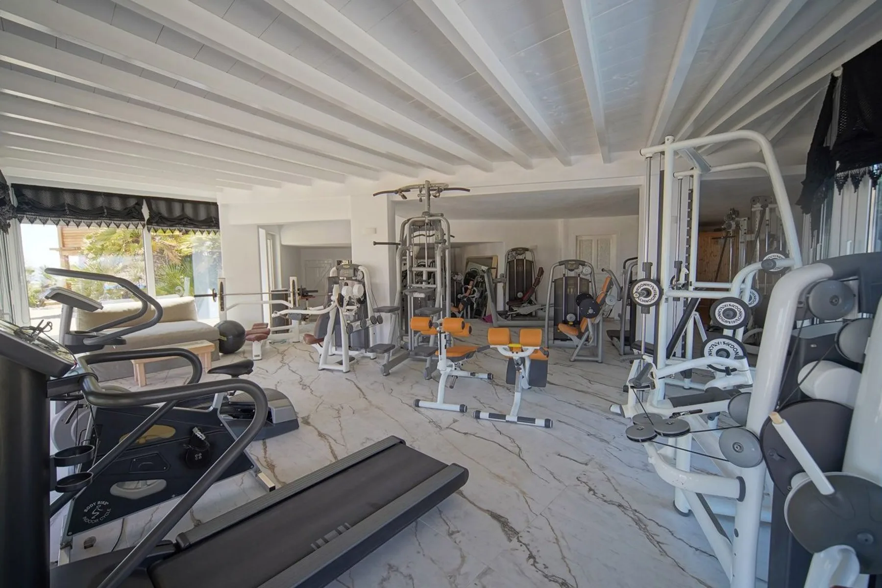 A home gym with exercise machines and weight-training equipment.