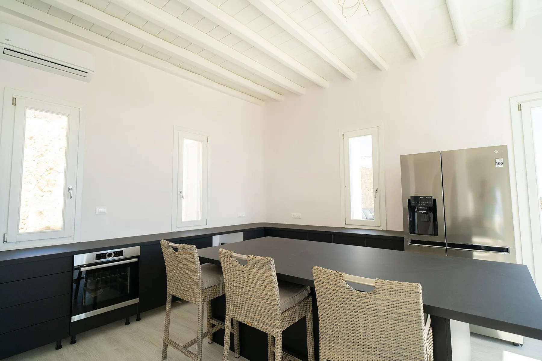A bright kitchen with a long island and woven seating.