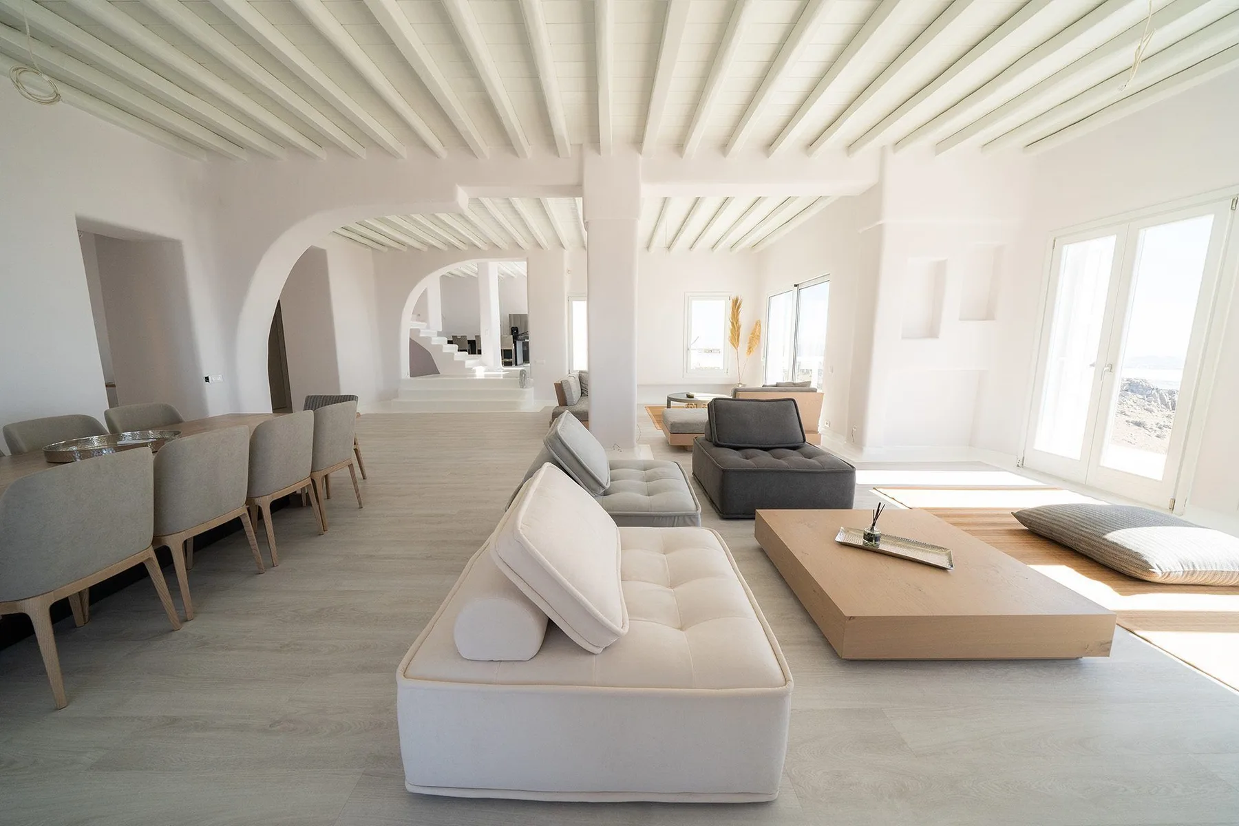 A bright living room with seating, a low table, and large windows.