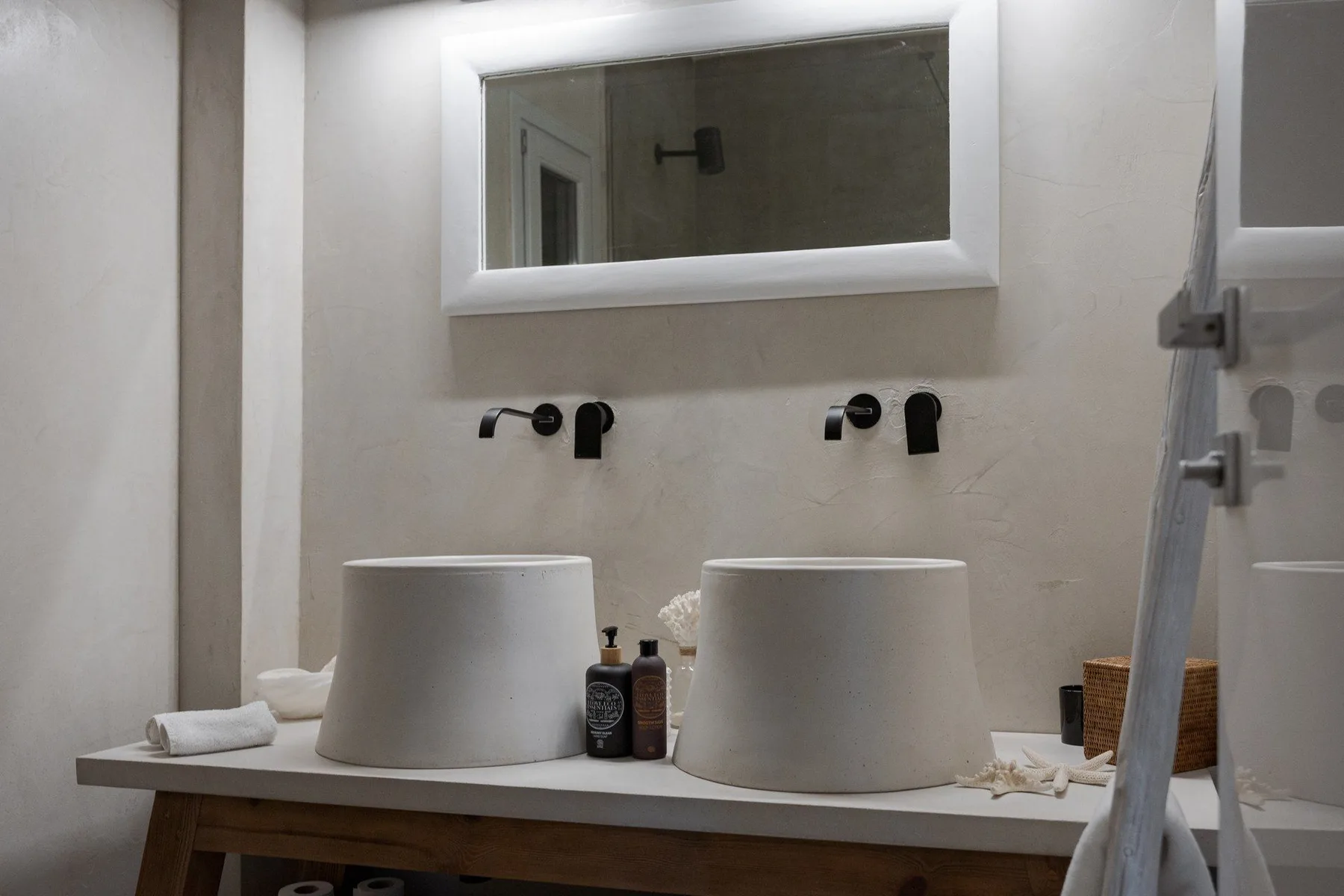 Un tocador de baño con dos lavabos sobre encimera bajo un espejo amplio.