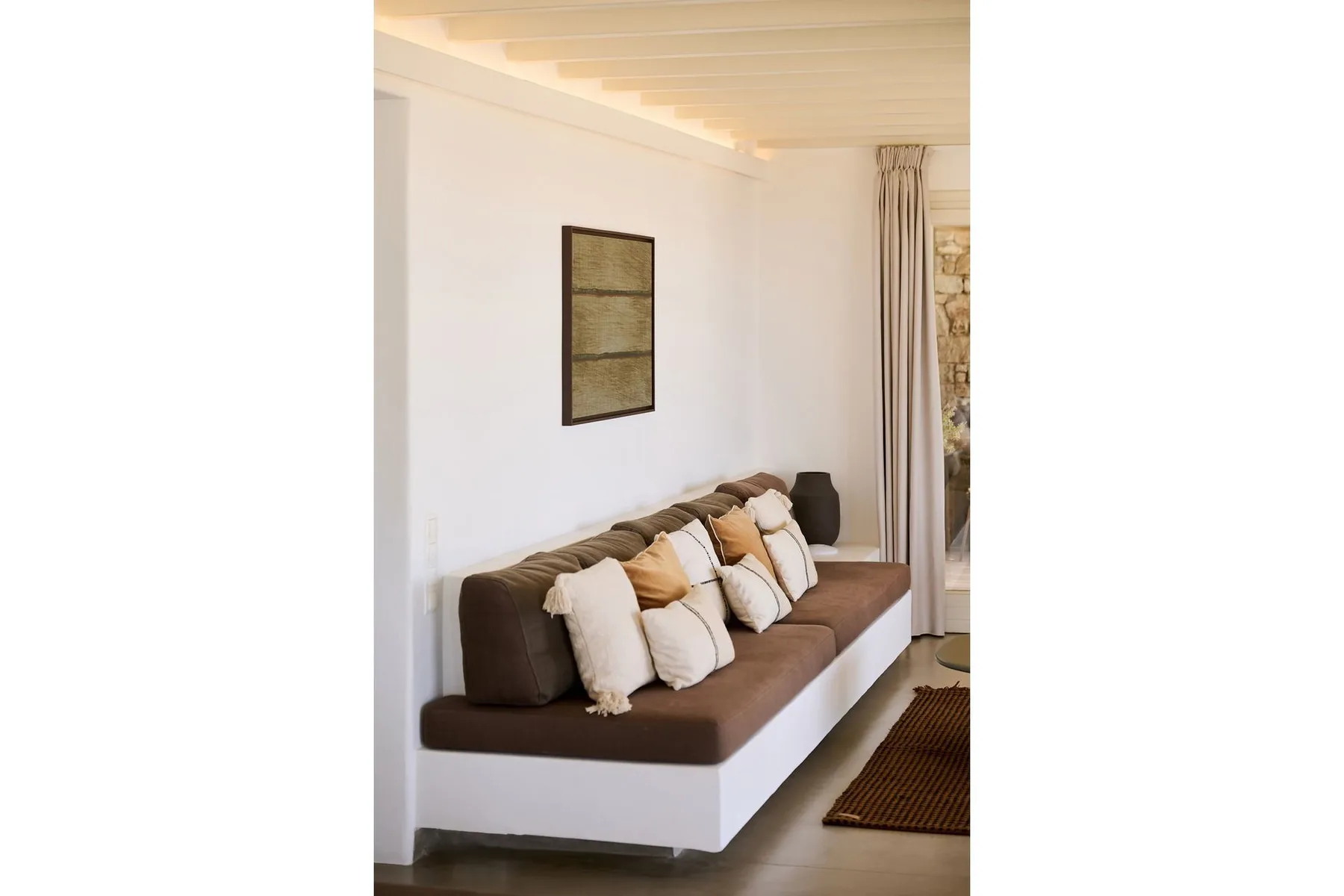A living room with a brown sofa and light-colored cushions.