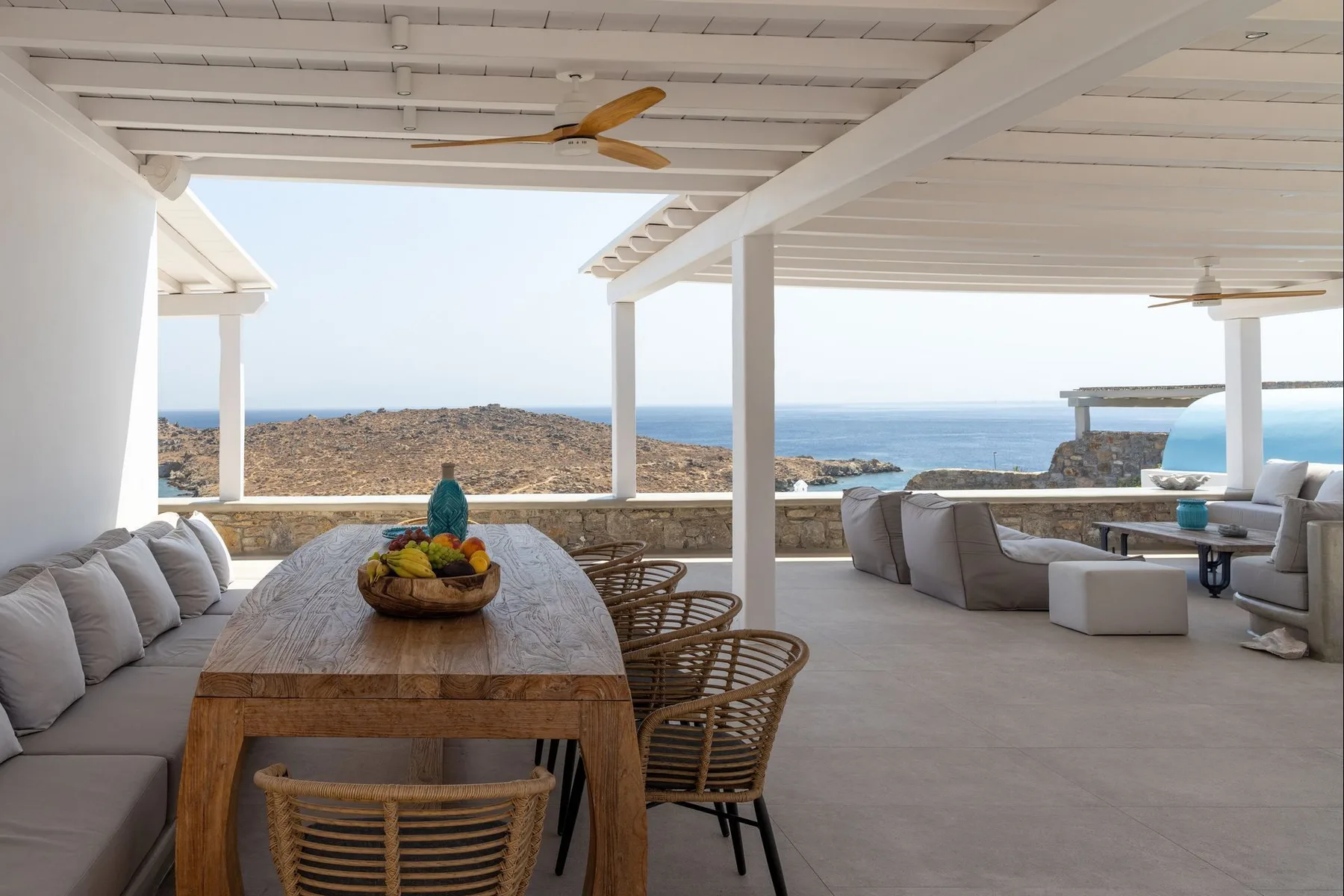 A covered outdoor dining and lounge area overlooks the sea.