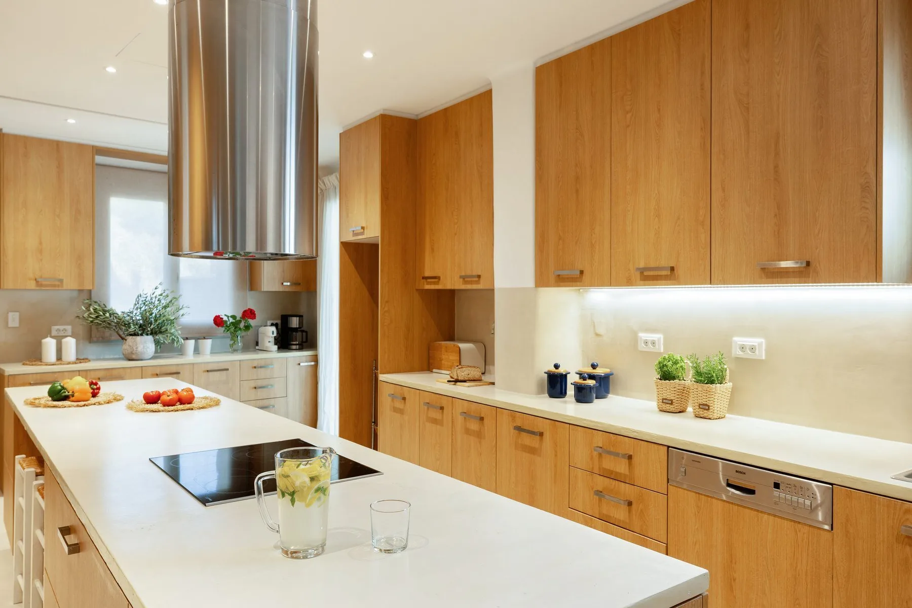 A bright kitchen with wooden cabinets and a white island.