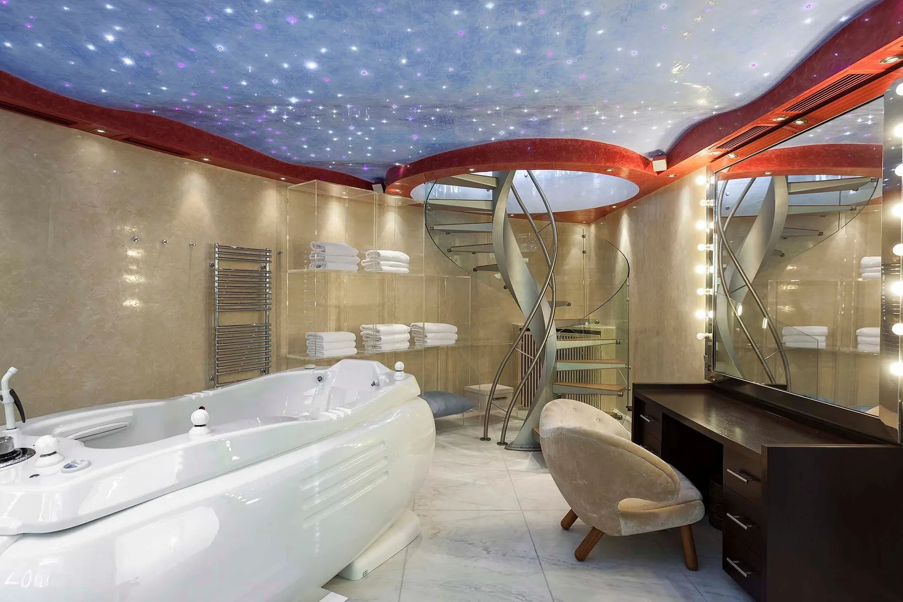 A spacious bathroom features a whirlpool tub, curved staircase, and illuminated ceiling.