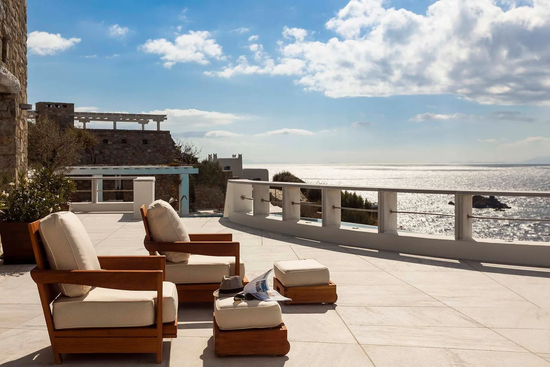 A seaside terrace with cushioned seating and a view of the water.