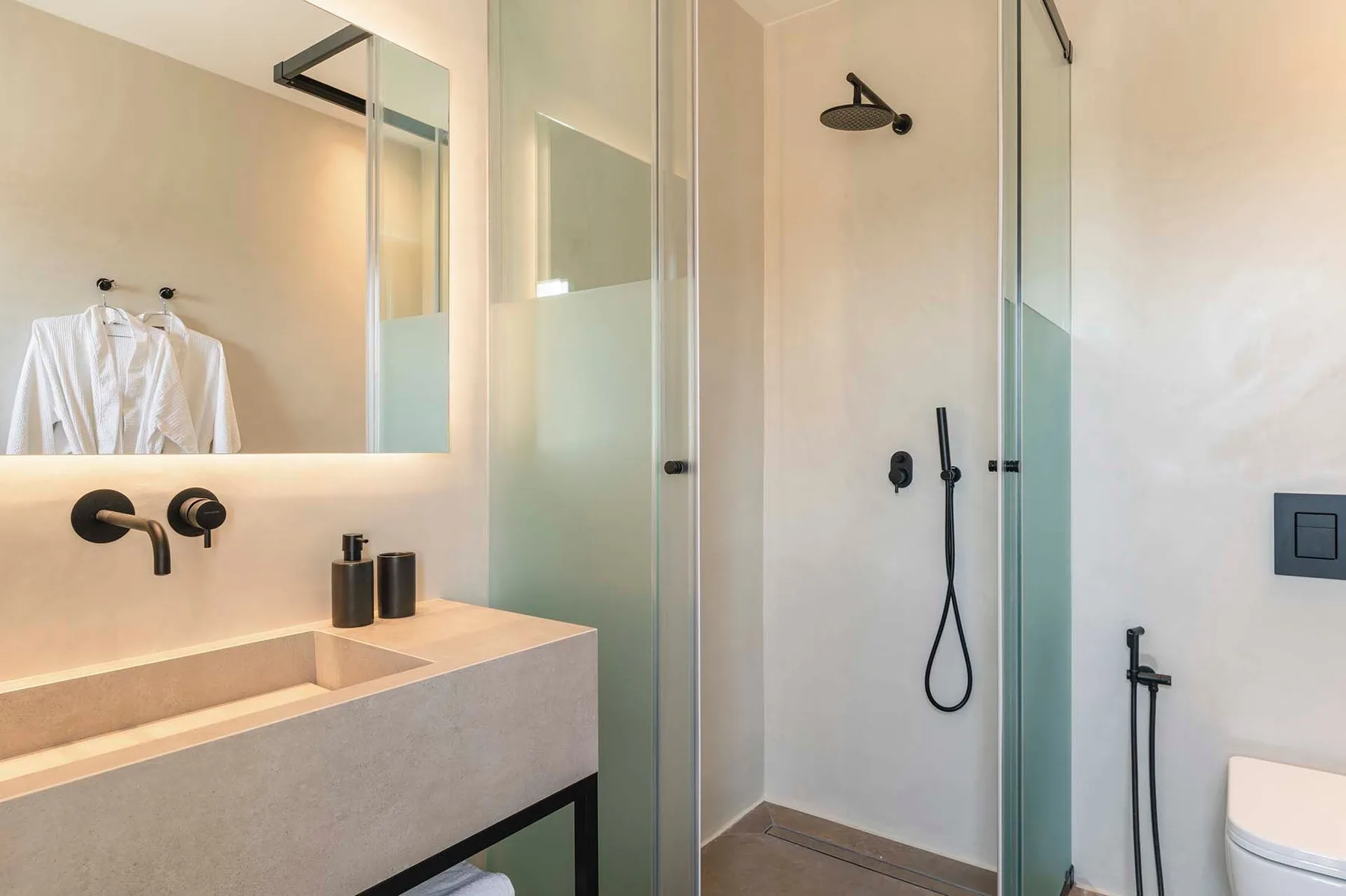 A modern bathroom with a wide vanity, mirror, and glass shower.