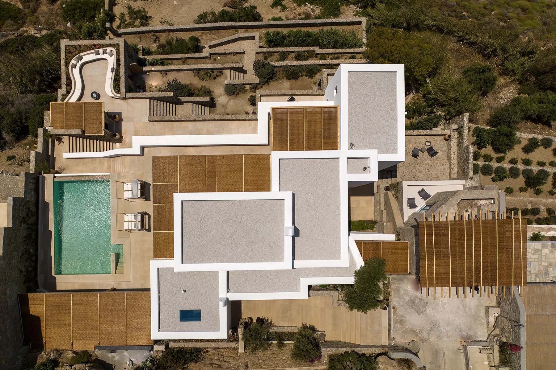 An aerial view of a modern home with a pool and landscaped outdoor areas.