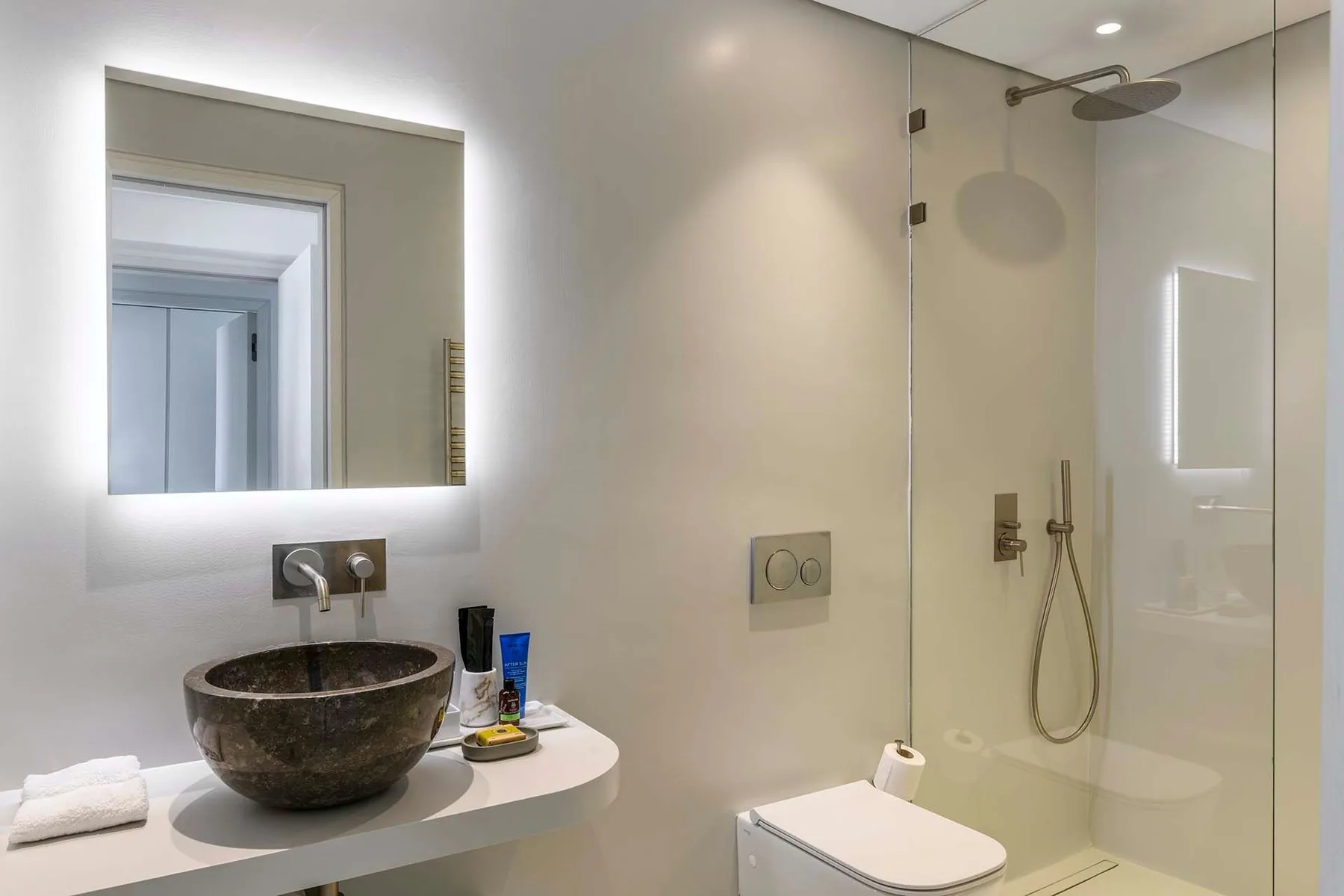 A modern bathroom with a vessel sink and glass-enclosed shower.