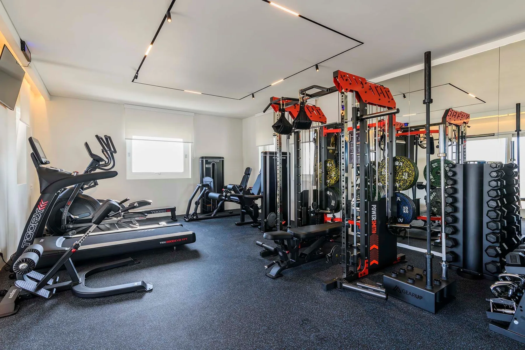 A gym with treadmills, weight machines, and free weights.