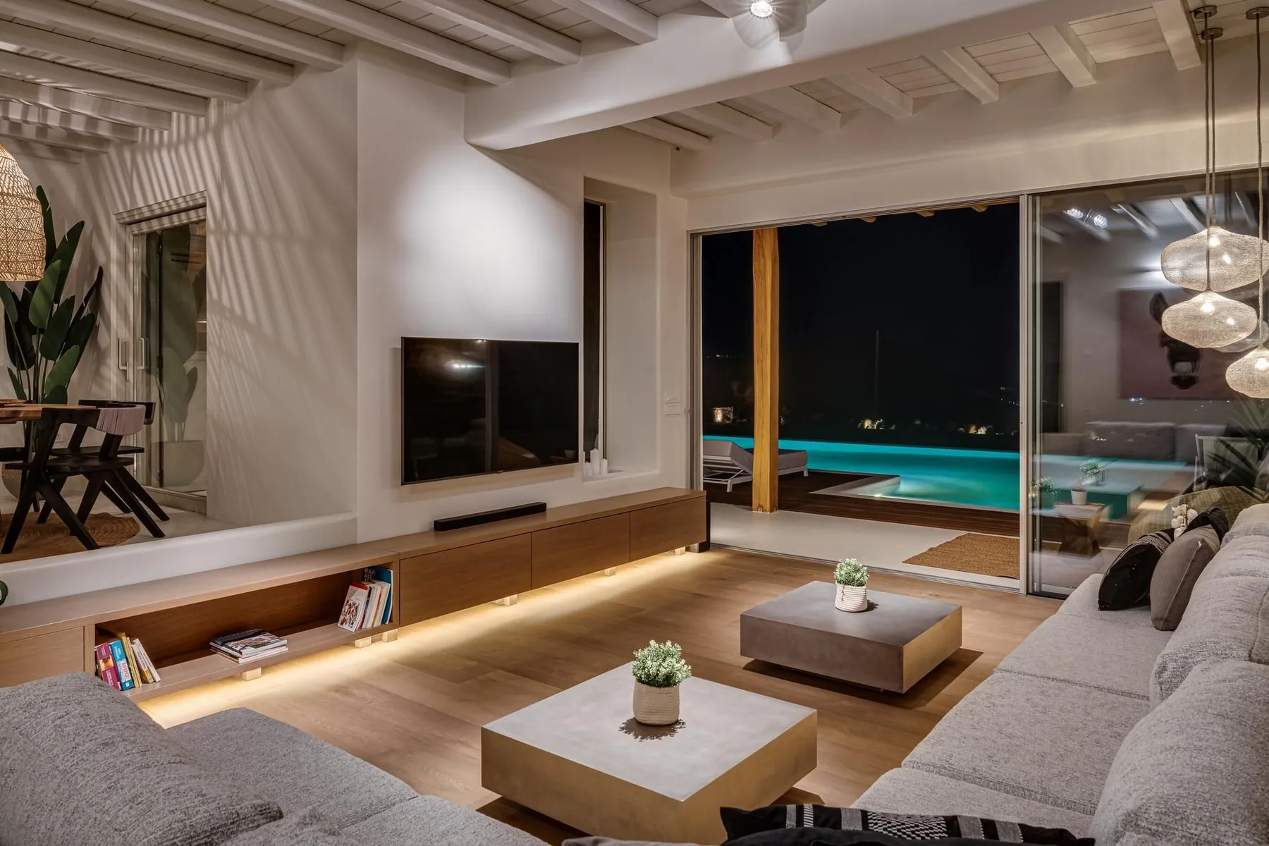 Una sala de estar moderna se abre a una terraza con piscina.