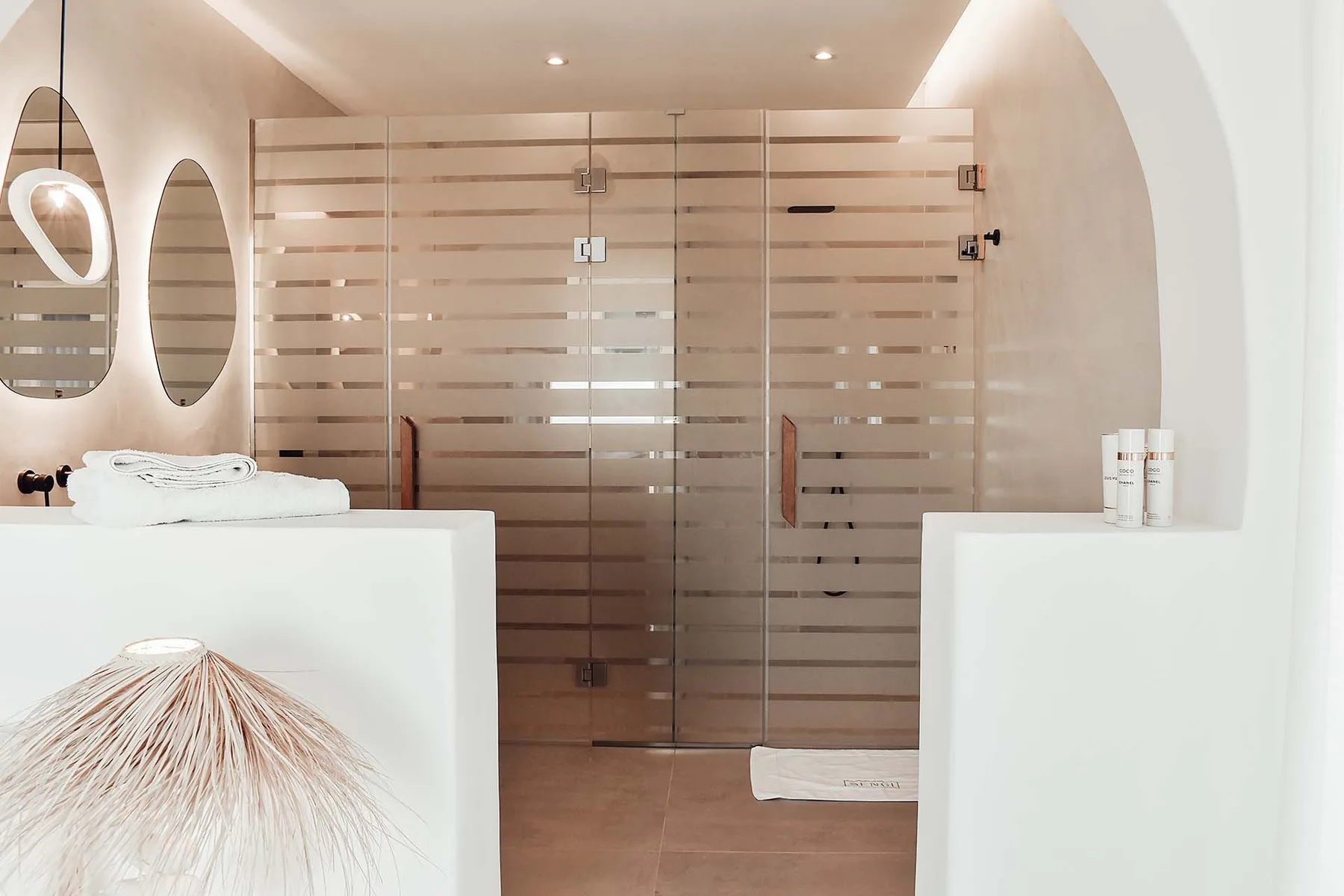 A bathroom with a glass shower enclosure and white sink counters.