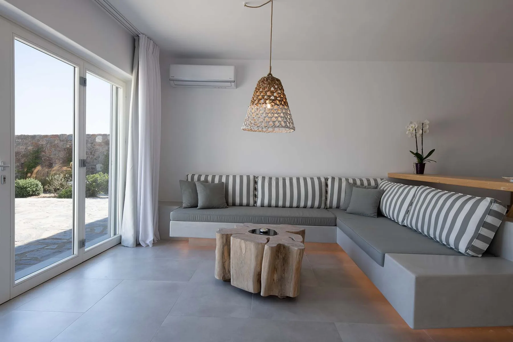 A modern living room with an L-shaped seating area beside large glass doors.