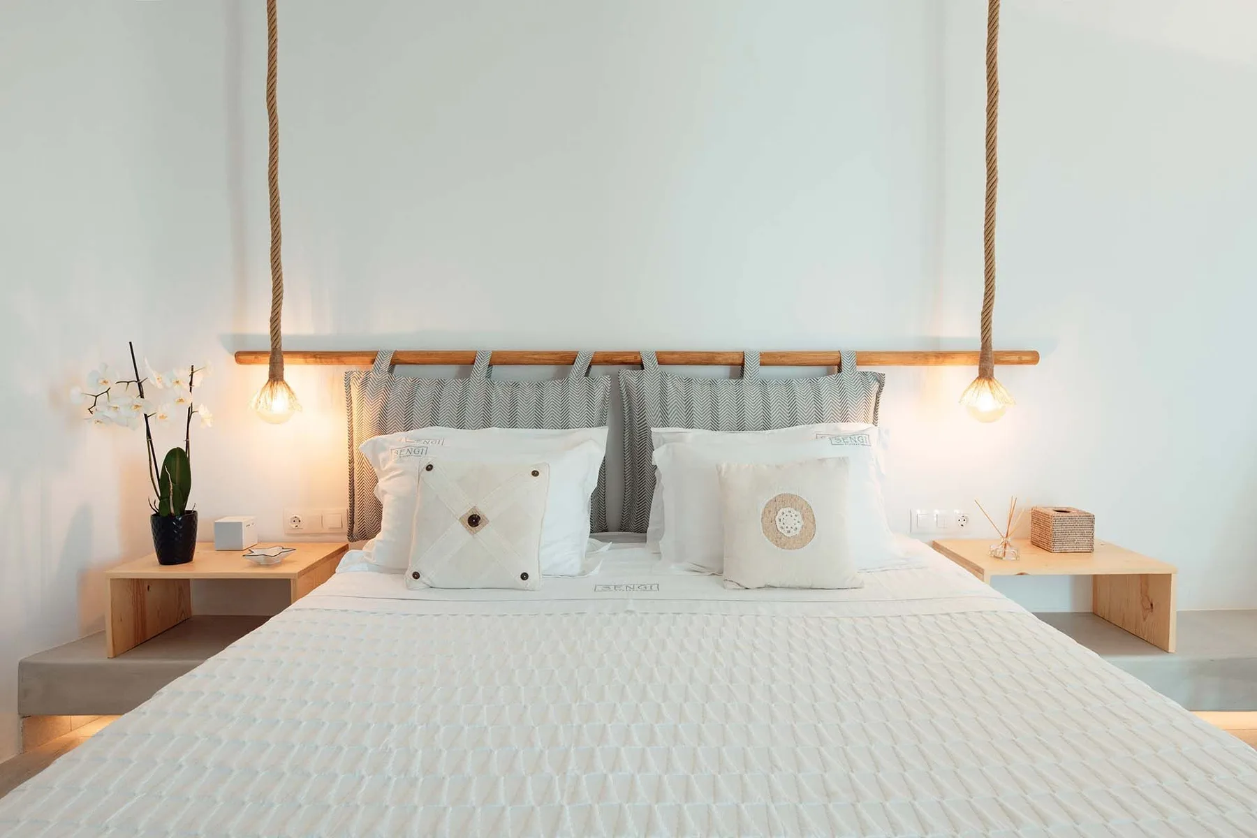 A bright bedroom with a neatly made bed and matching bedside tables.