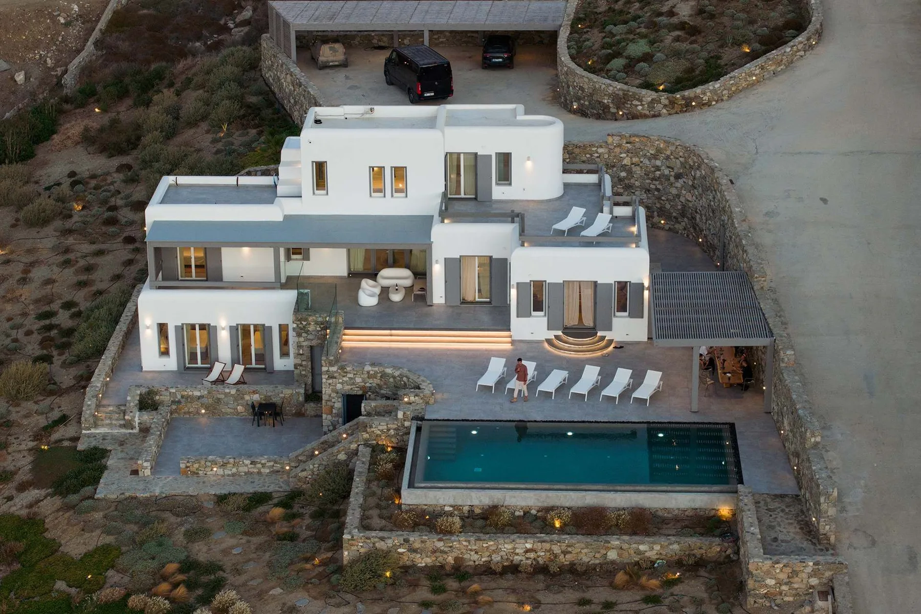 A modern white house with a swimming pool and outdoor seating.