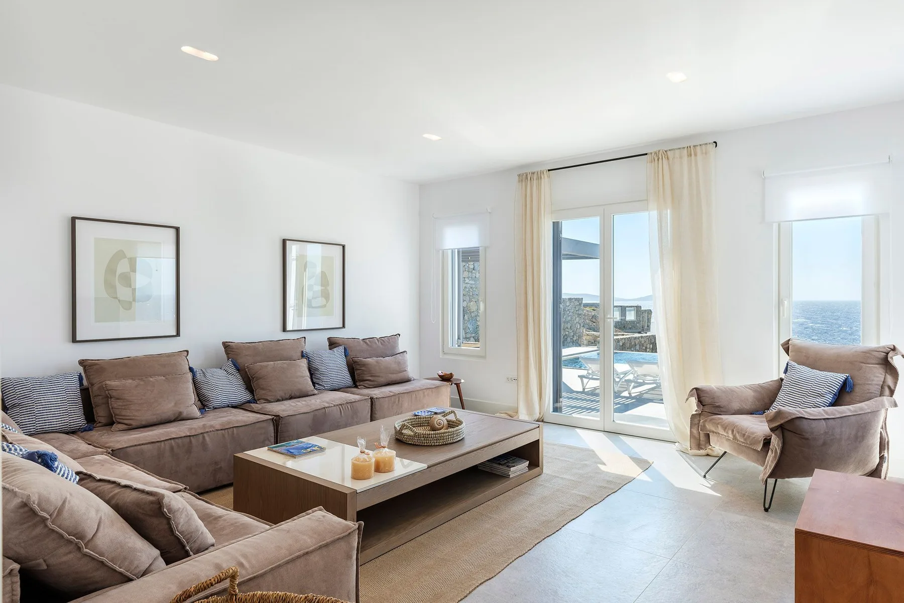 A bright living room with seating around a coffee table and glass doors.