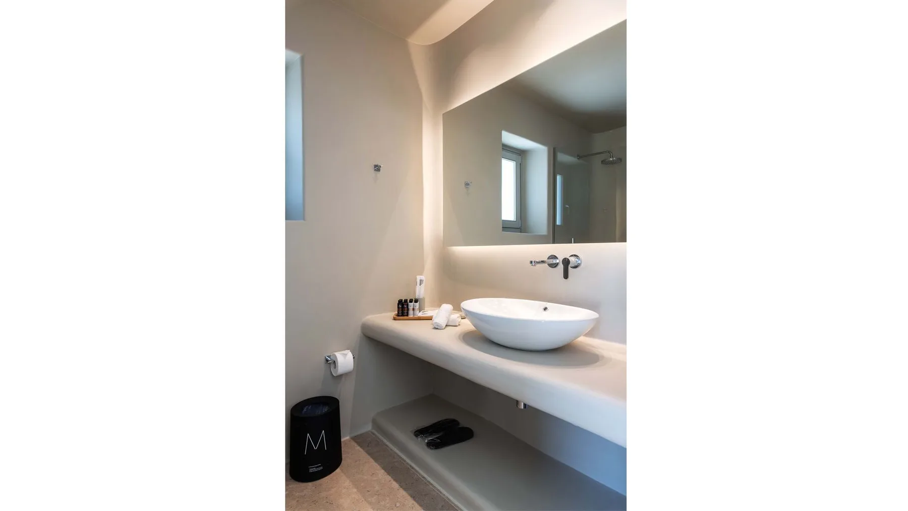 Bathroom vanity with a vessel sink and large wall mirror.