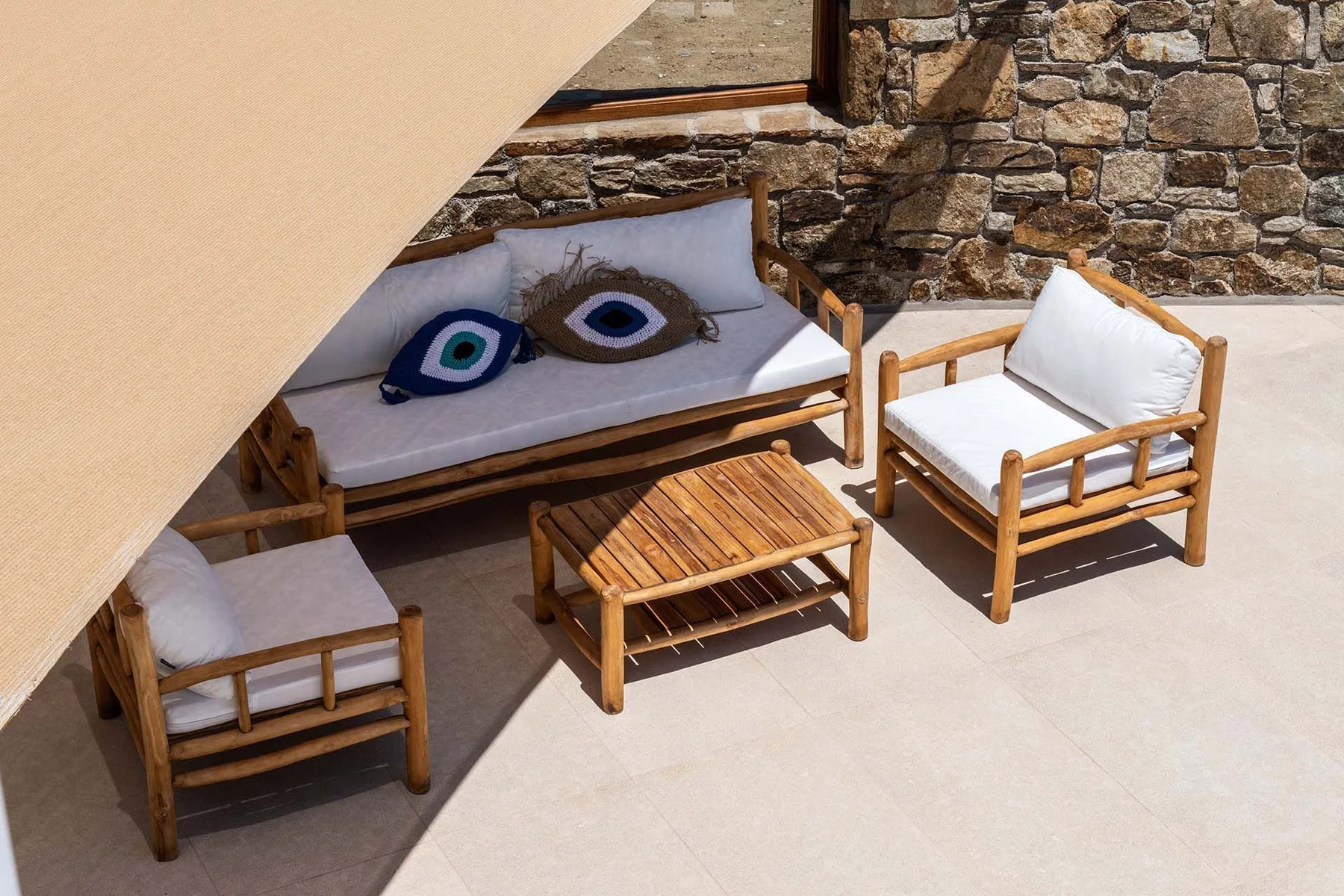 An outdoor seating area with wooden furniture and patterned cushions.
