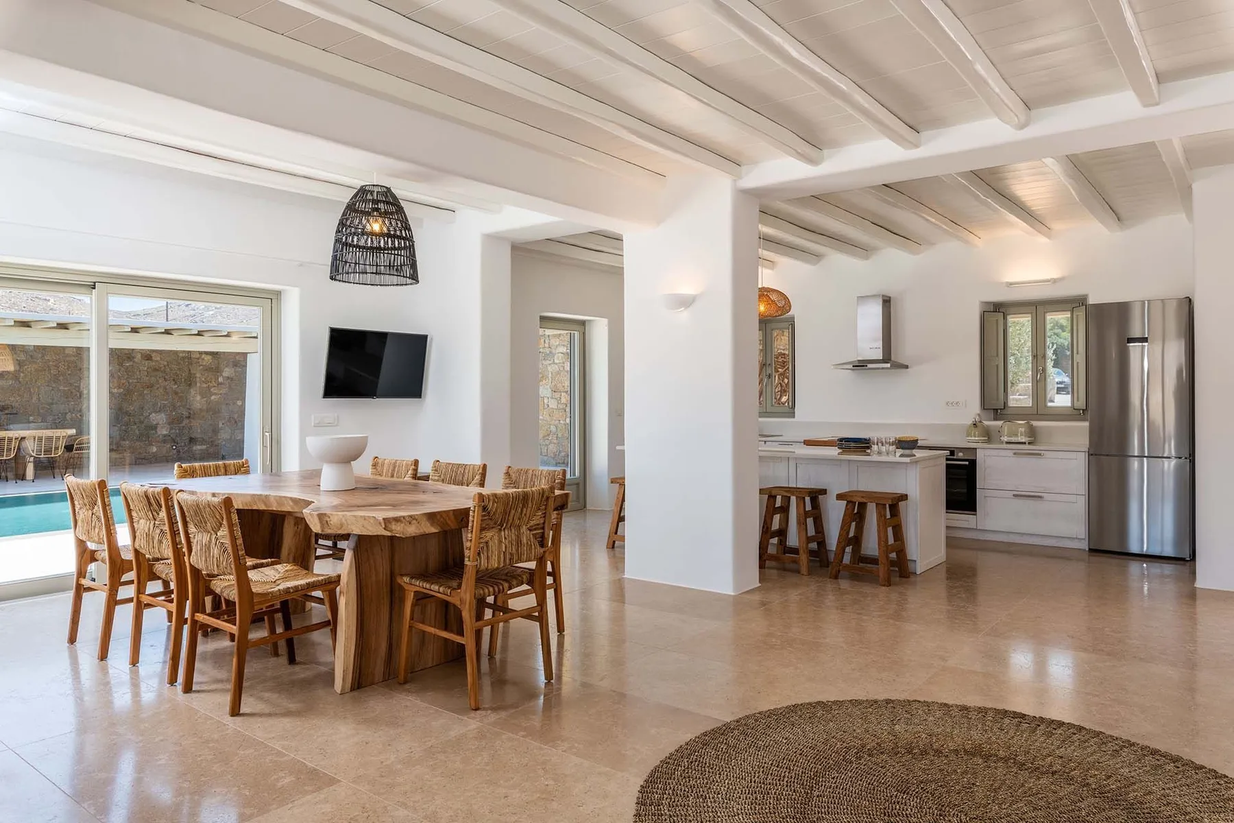 An open-plan dining and kitchen area with a wooden dining table and kitchen island.