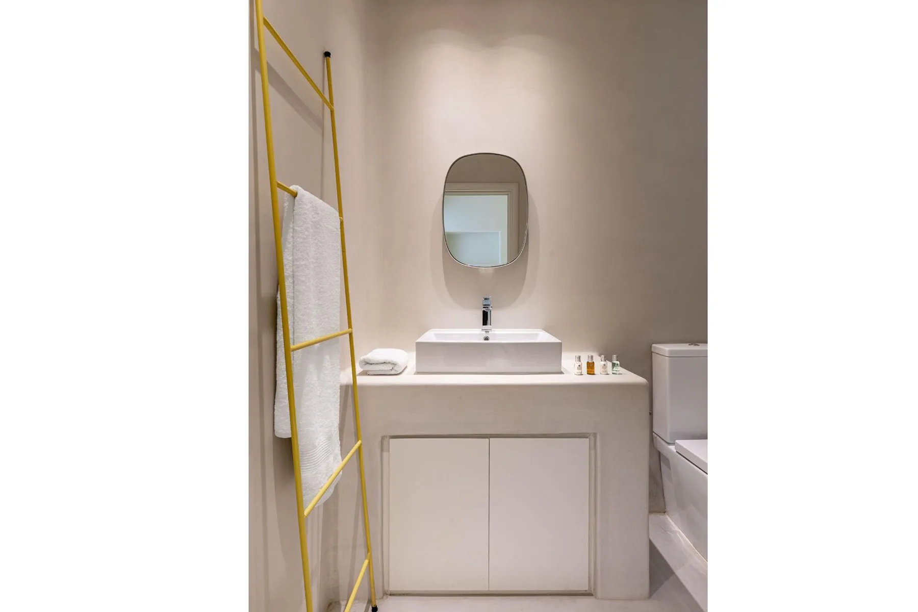 A bathroom vanity with a vessel sink and oval mirror.