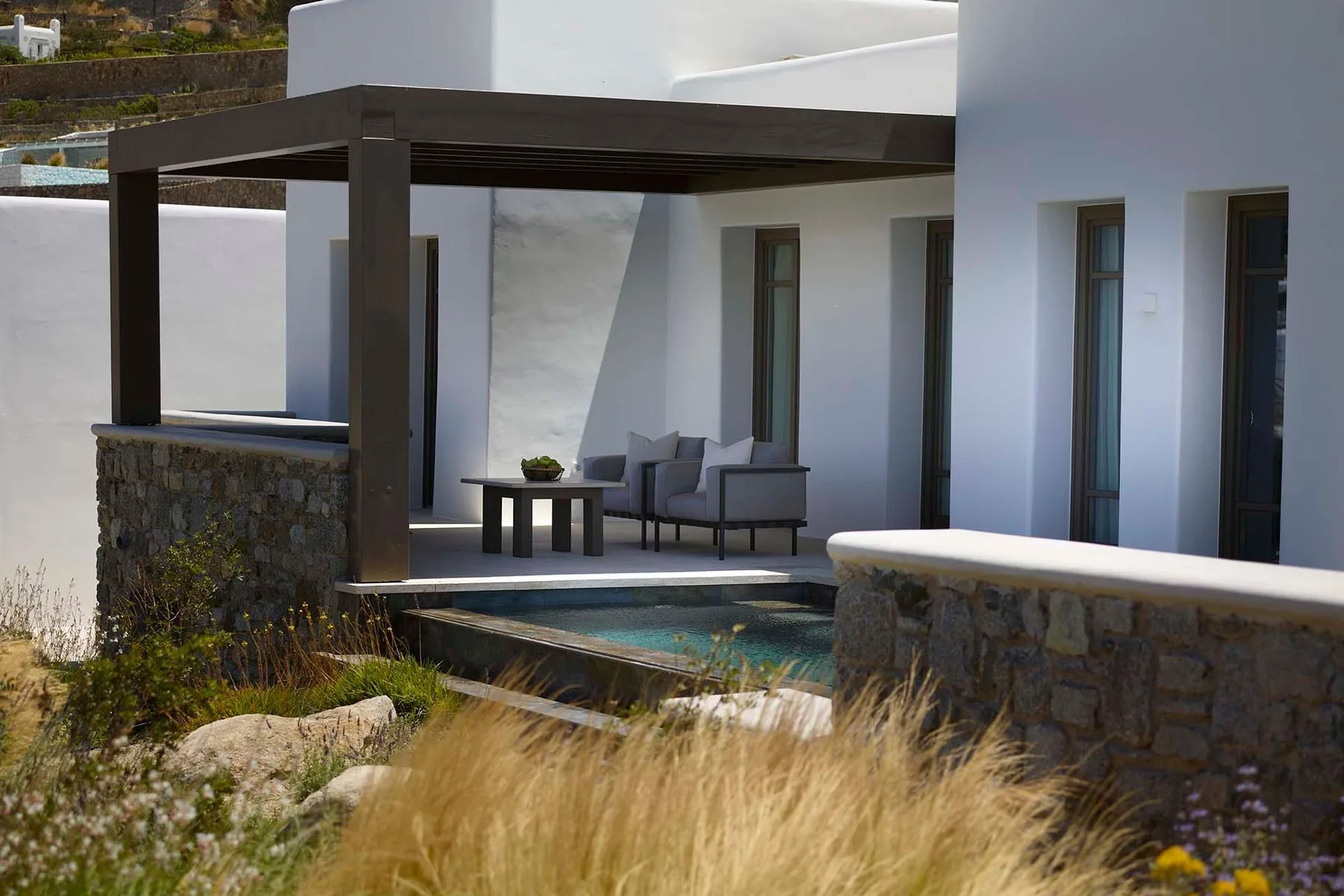 A modern patio with outdoor seating beside a small pool.