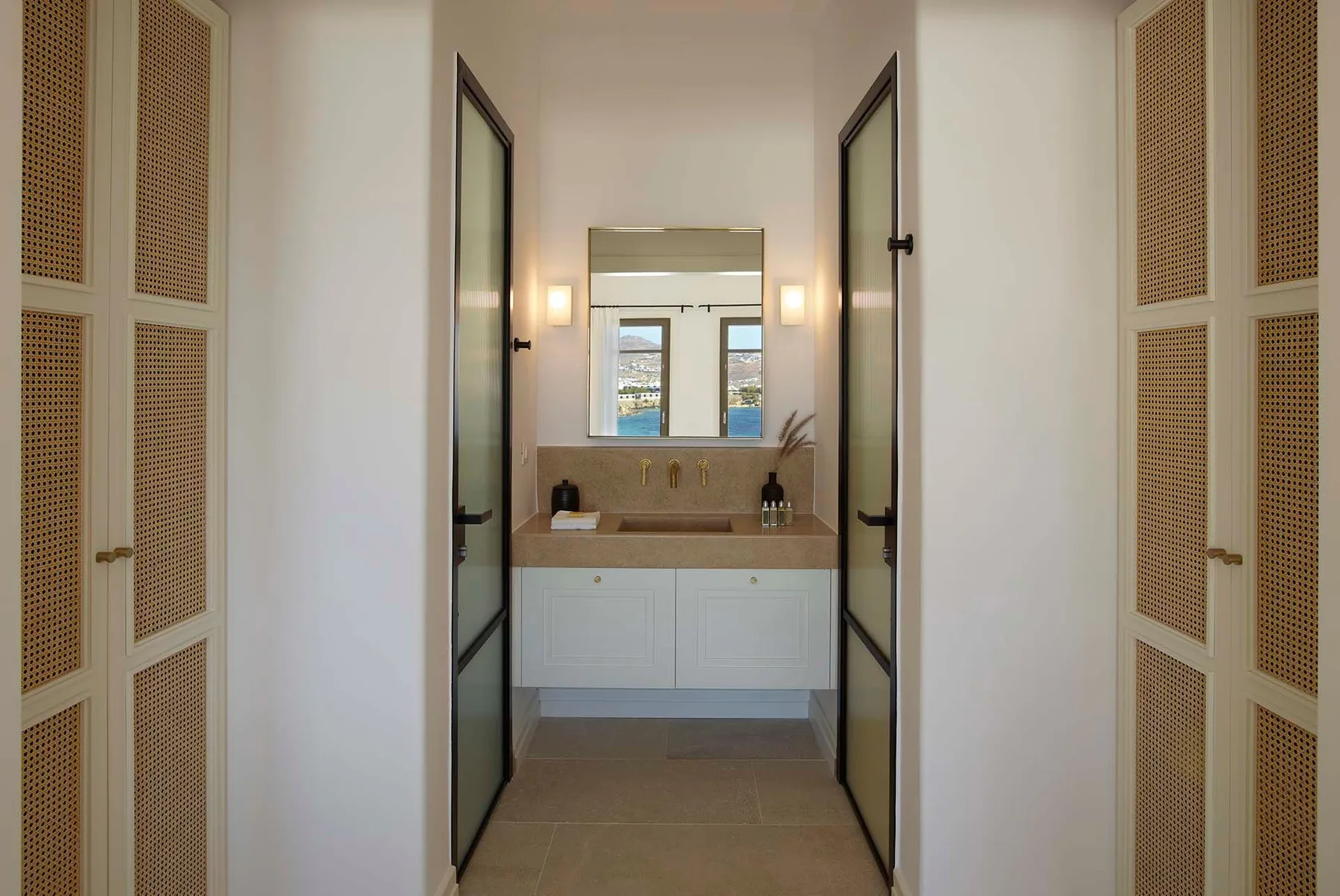 A bathroom vanity is visible through open doors, with a mirror above the sink.