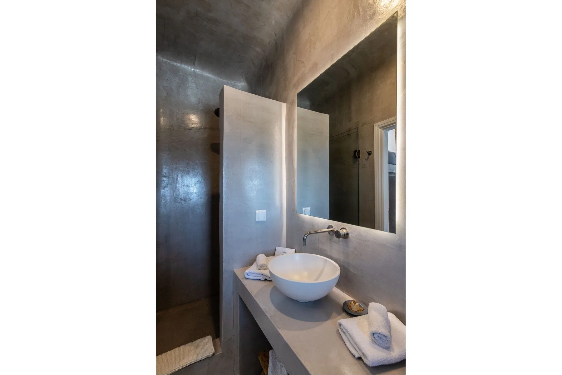 A modern bathroom with a vessel sink and large wall mirror.