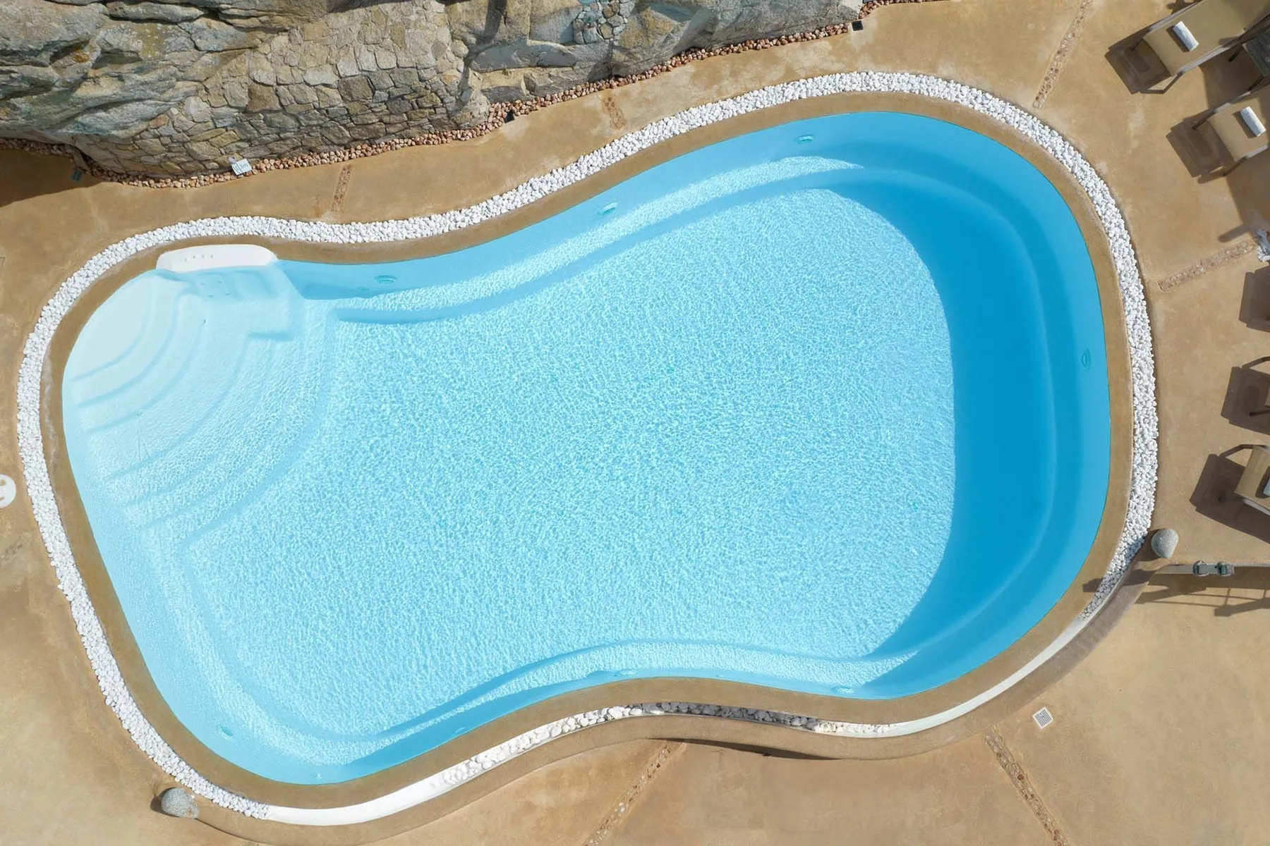 An overhead view of a swimming pool with curved edges.