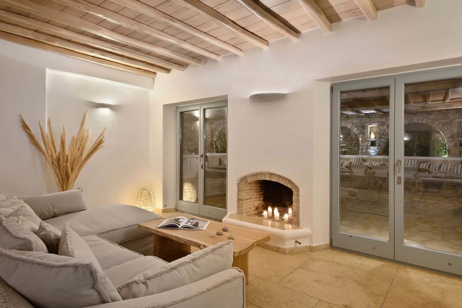 A living room with seating, a coffee table, and a lit fireplace.
