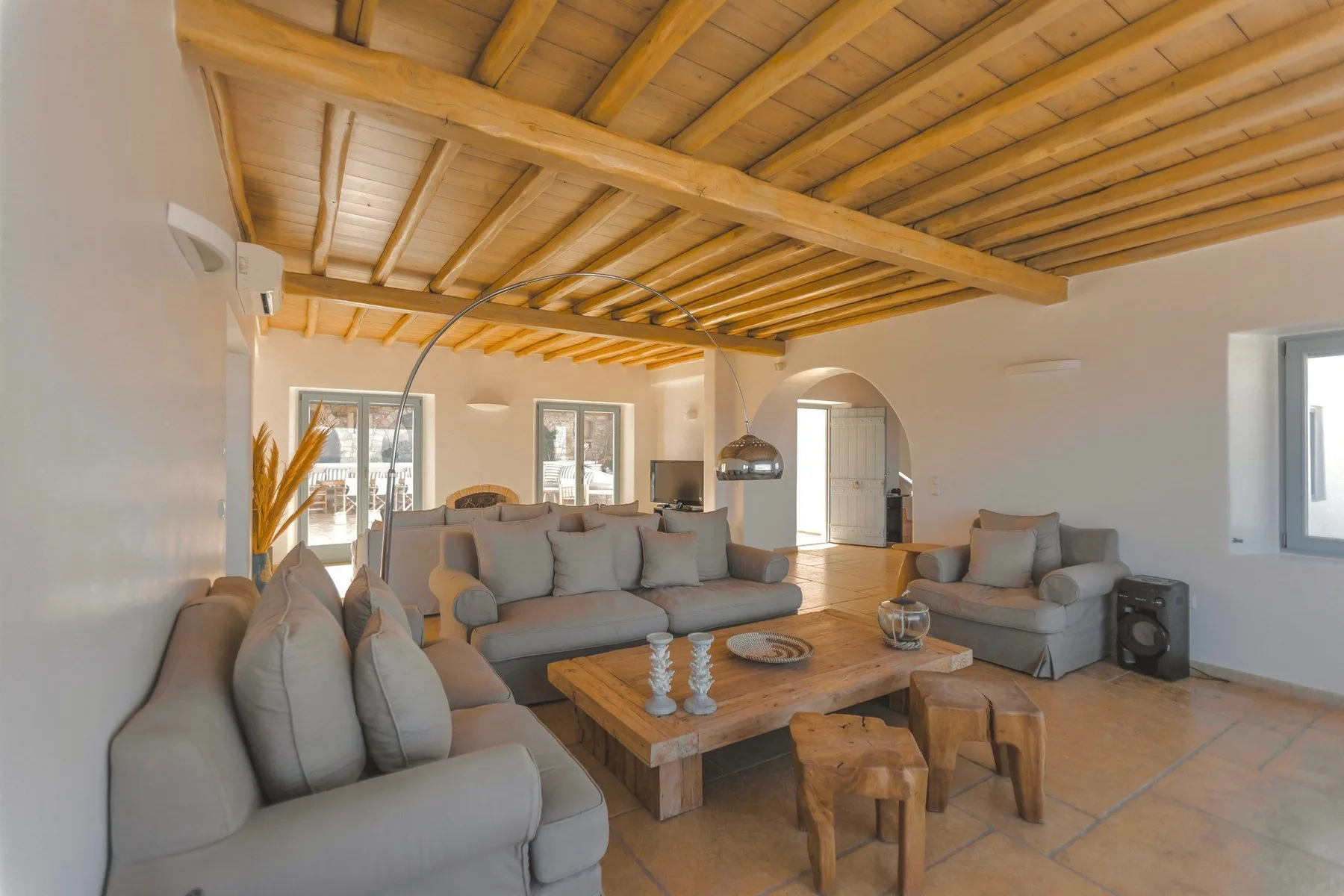 A spacious living room with gray seating arranged around a wooden coffee table.
