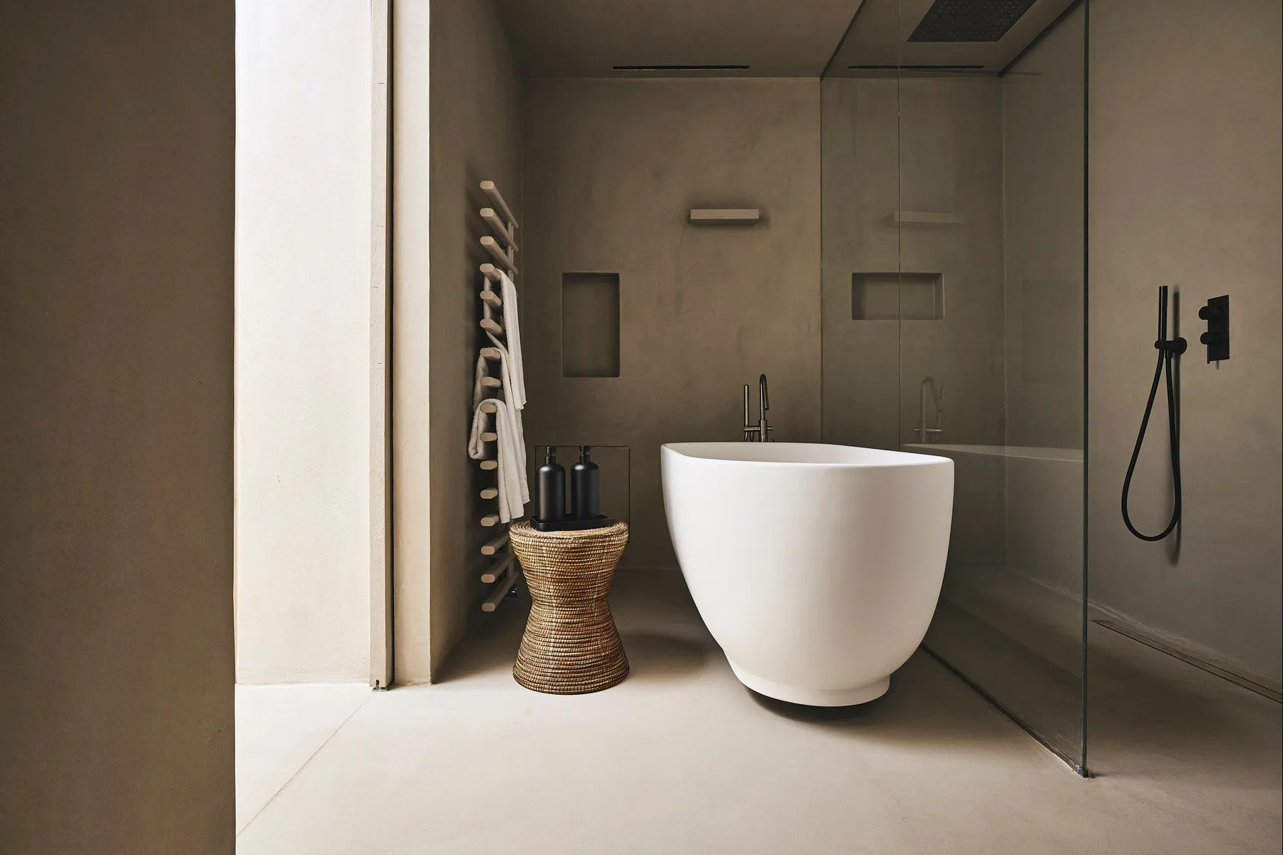 A modern bathroom features a freestanding bathtub beside a glass shower.