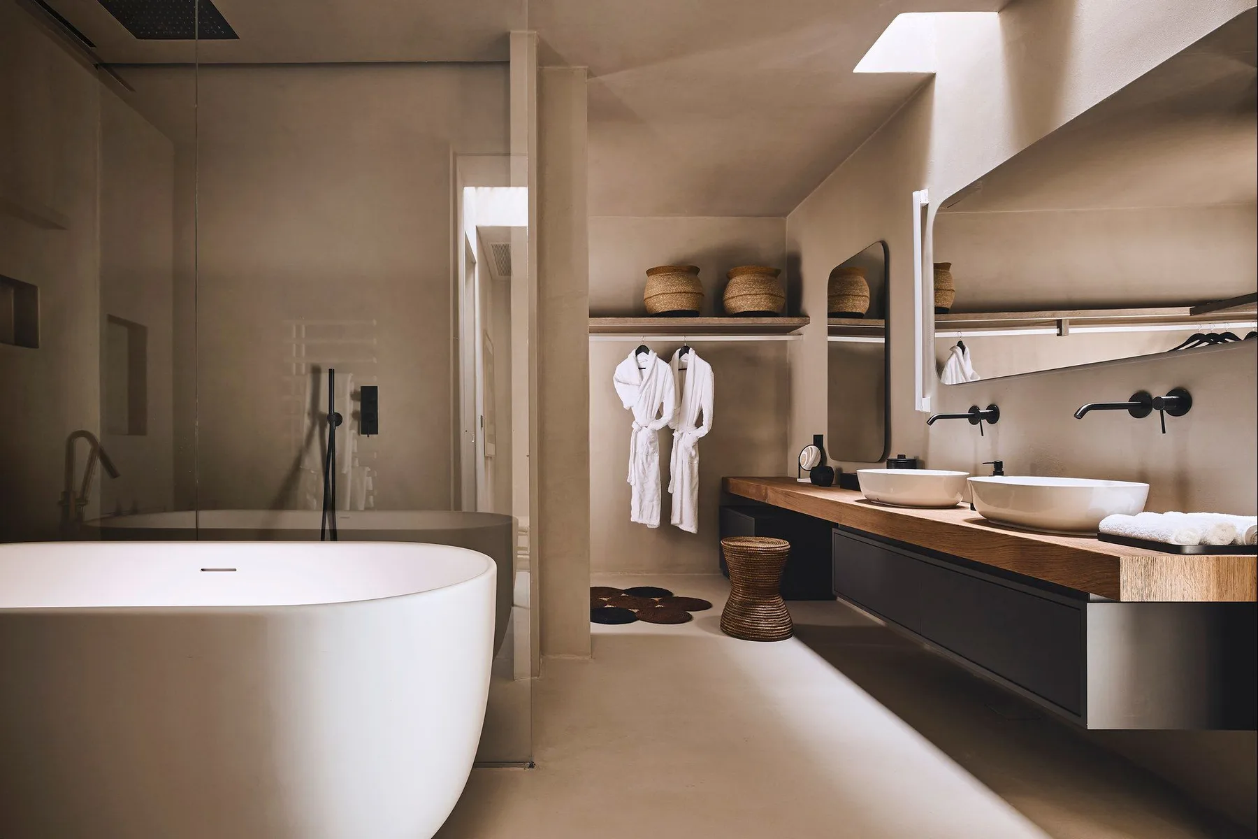 A bathroom with a bathtub and a long vanity topped with two sinks.