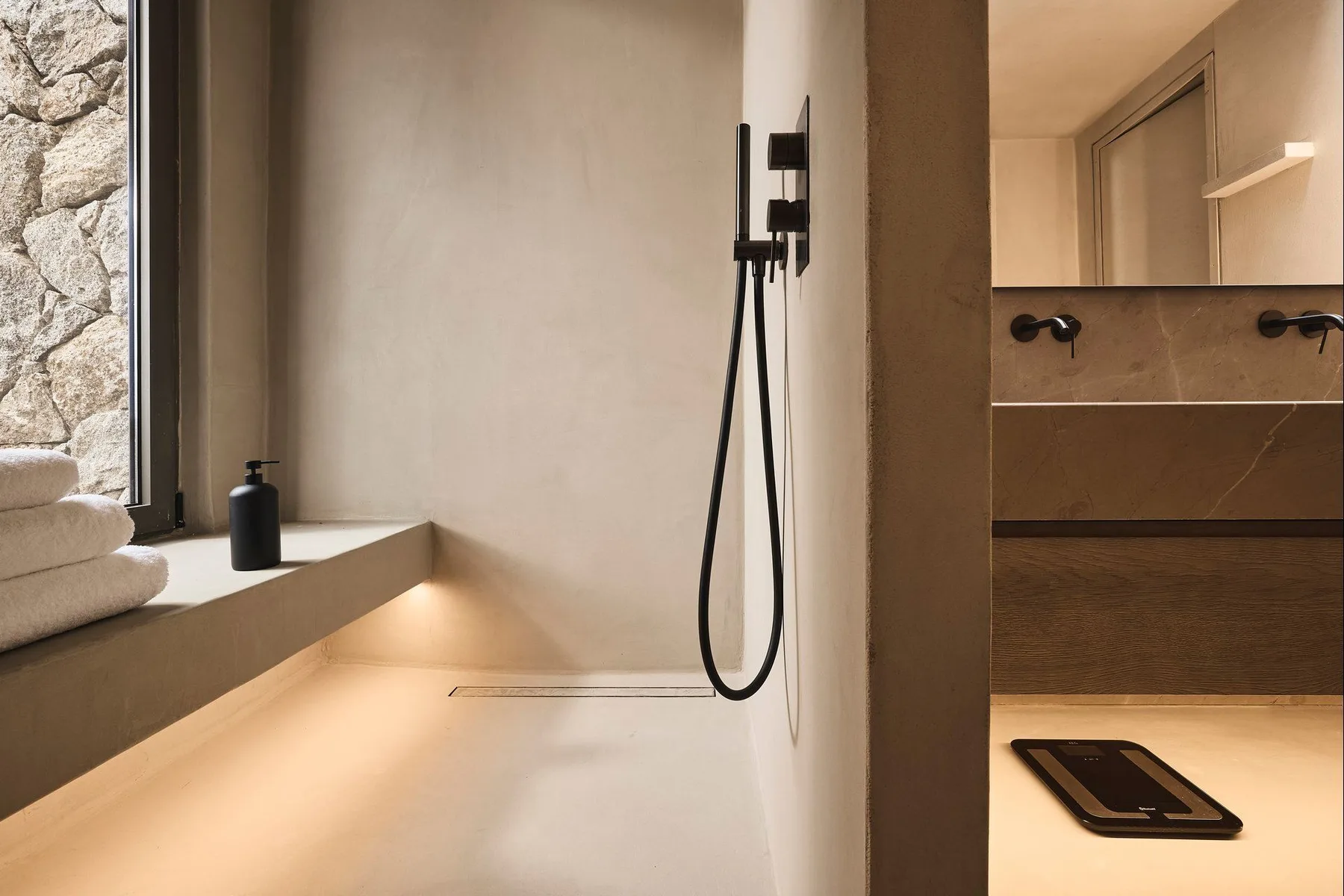 A modern bathroom with a walk-in shower and a vanity.