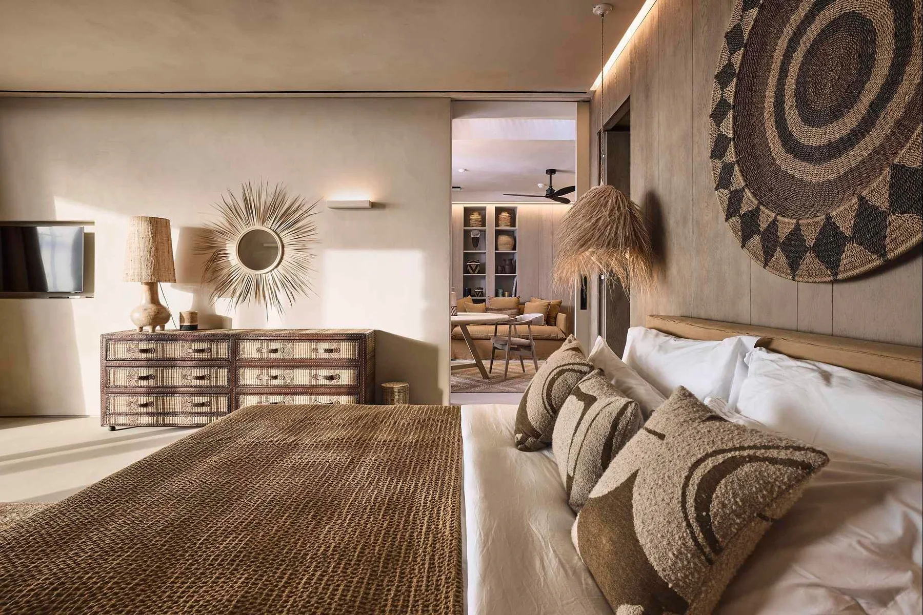A warmly decorated bedroom with a woven bedspread and patterned wall hanging.