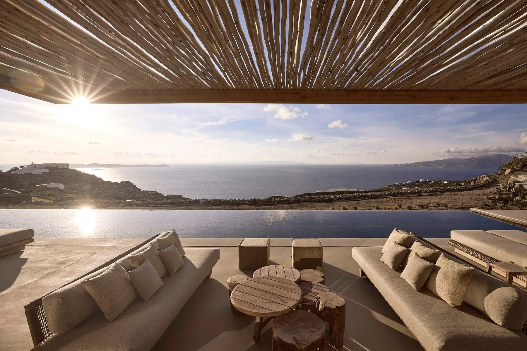A seaside terrace with cushioned seating and a view of the ocean.