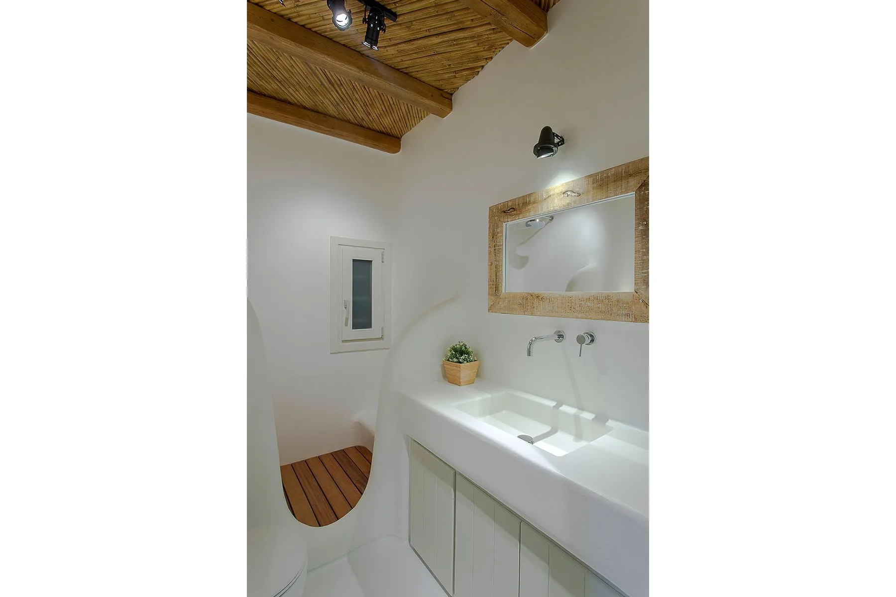 A bathroom vanity with a sink, wall mirror, and wooden ceiling.