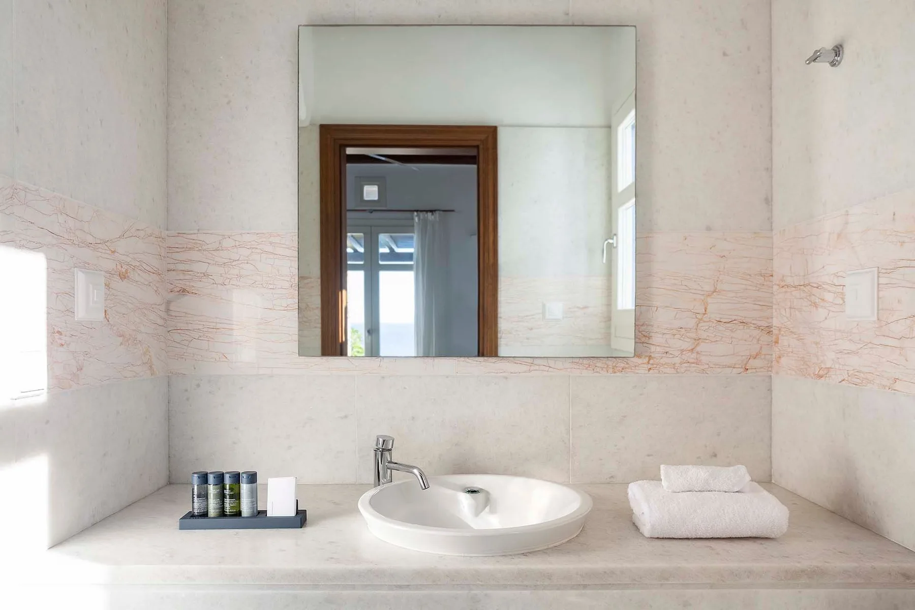 A bathroom vanity with a basin, mirror, and folded towels.