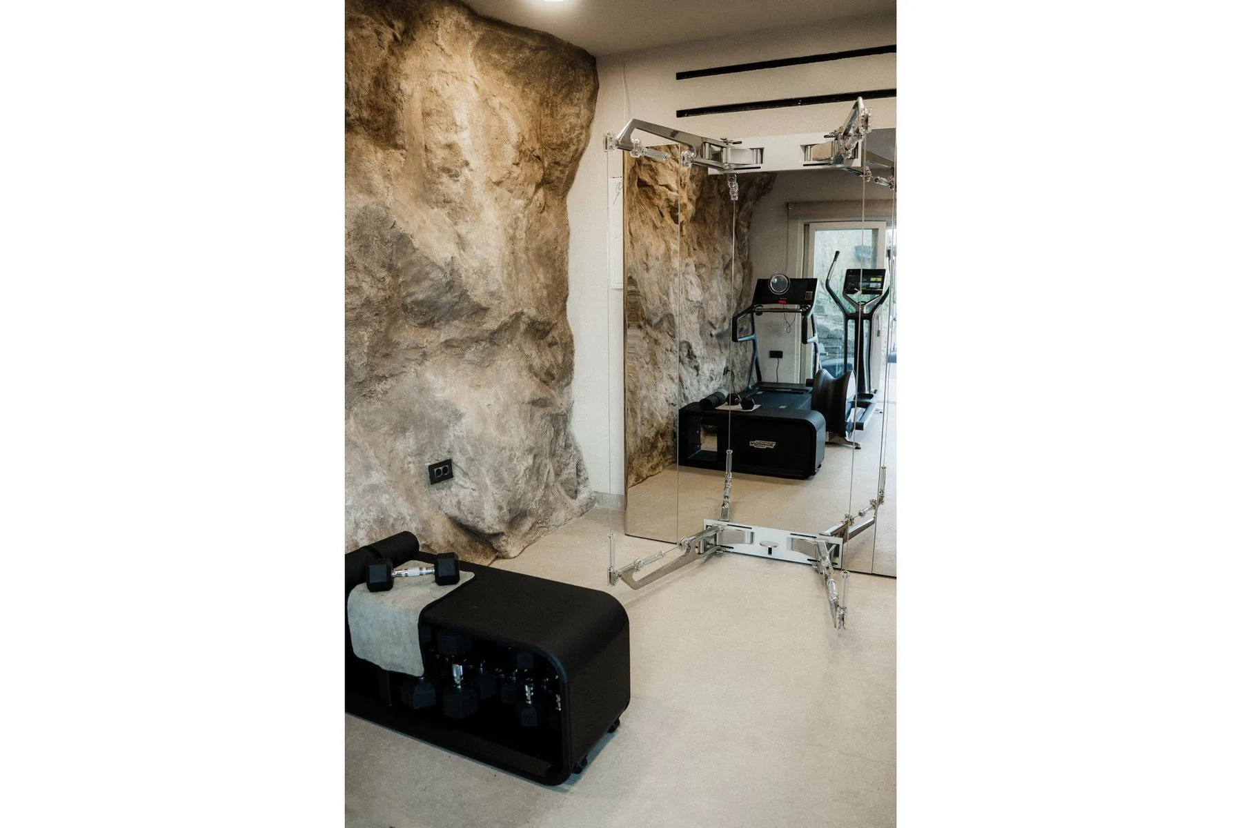 A compact exercise area with fitness equipment and a large wall mirror.
