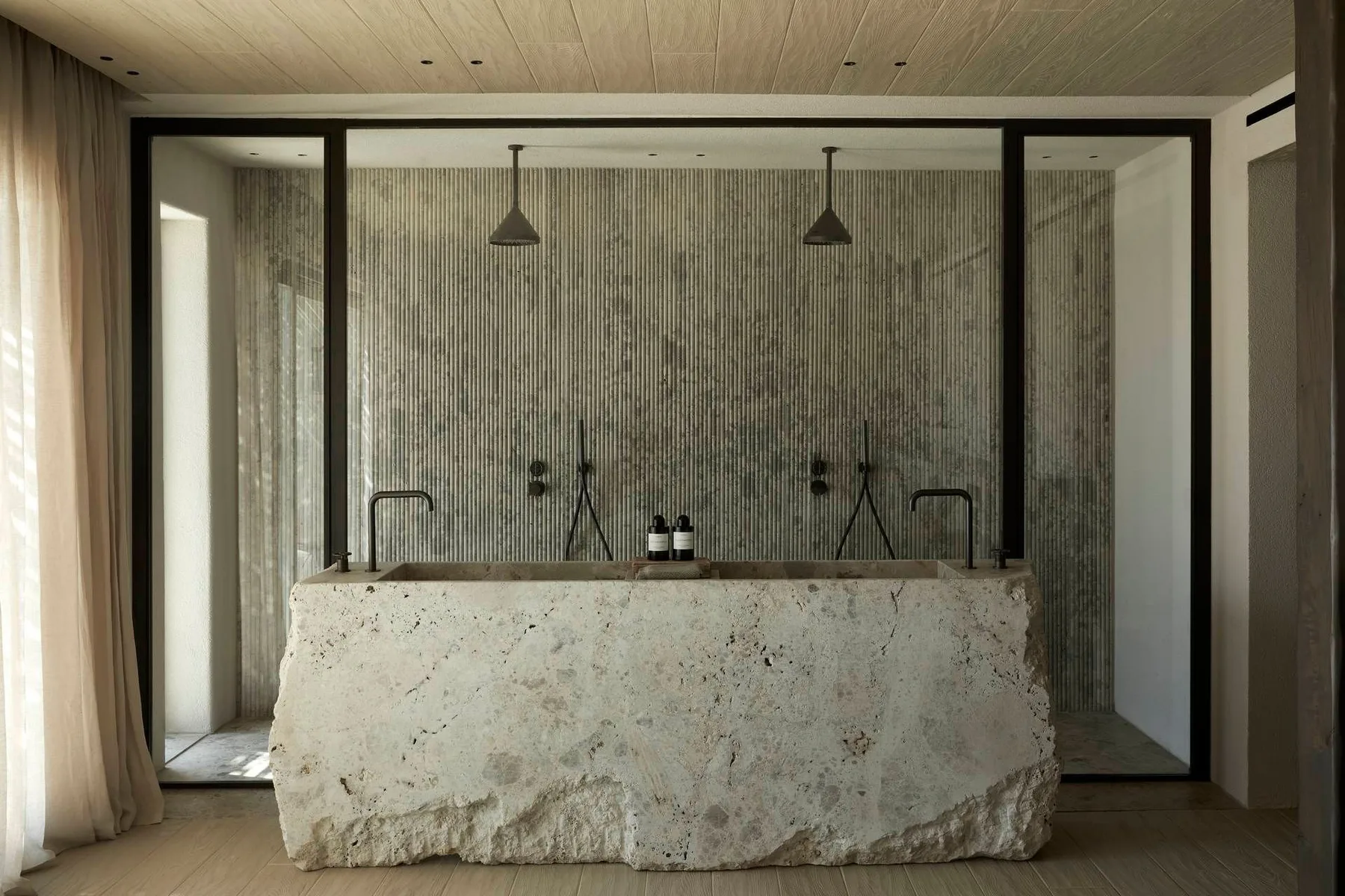 A modern bathroom vanity stands in front of a glass-enclosed shower.
