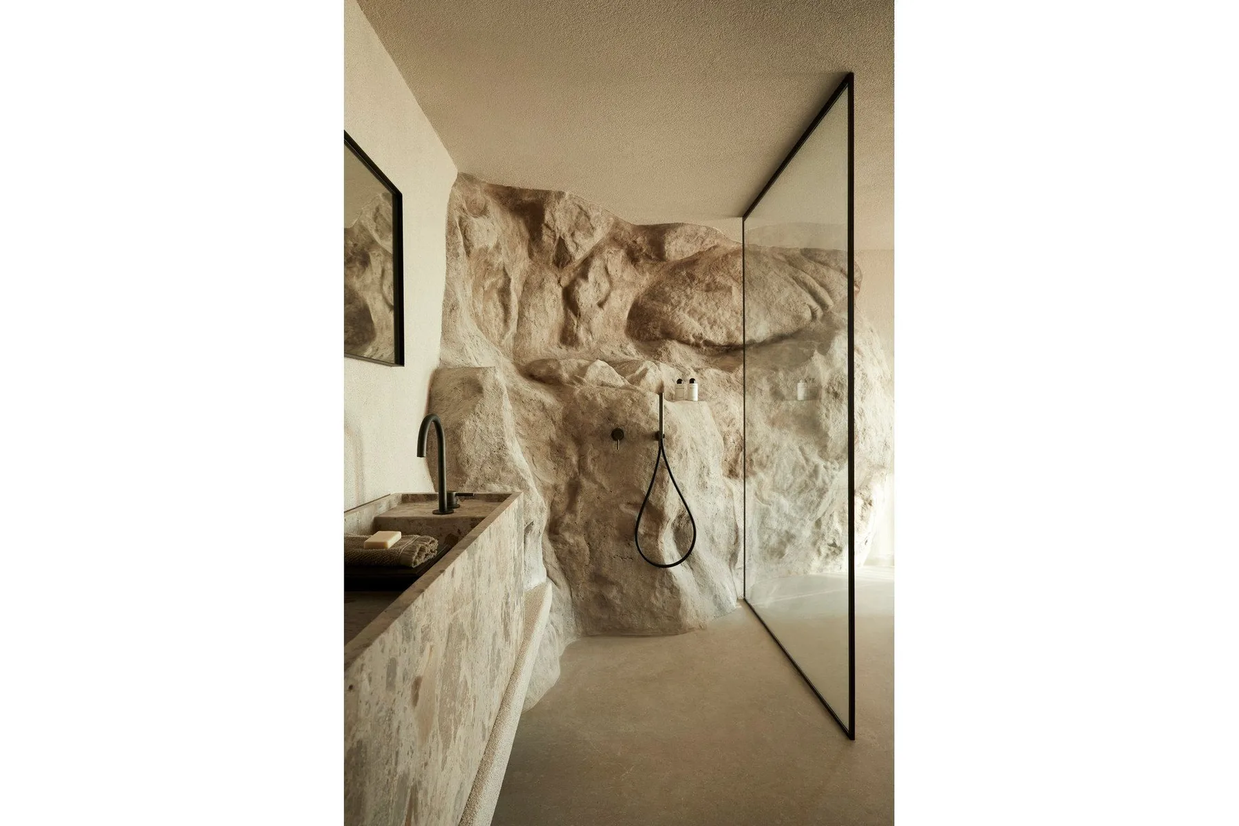A bathroom with a walk-in shower beside a stone vanity.