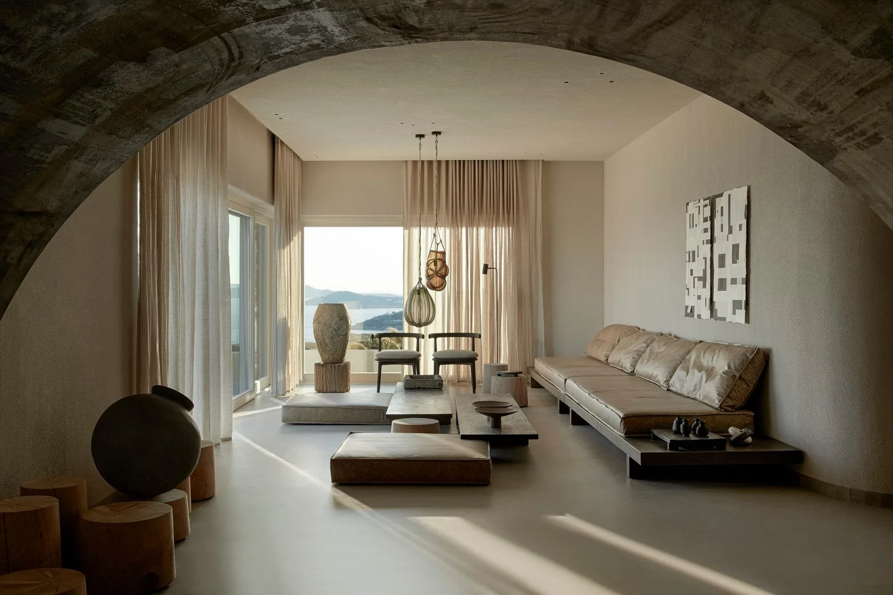 A bright living room with seating, a low table, and large windows.