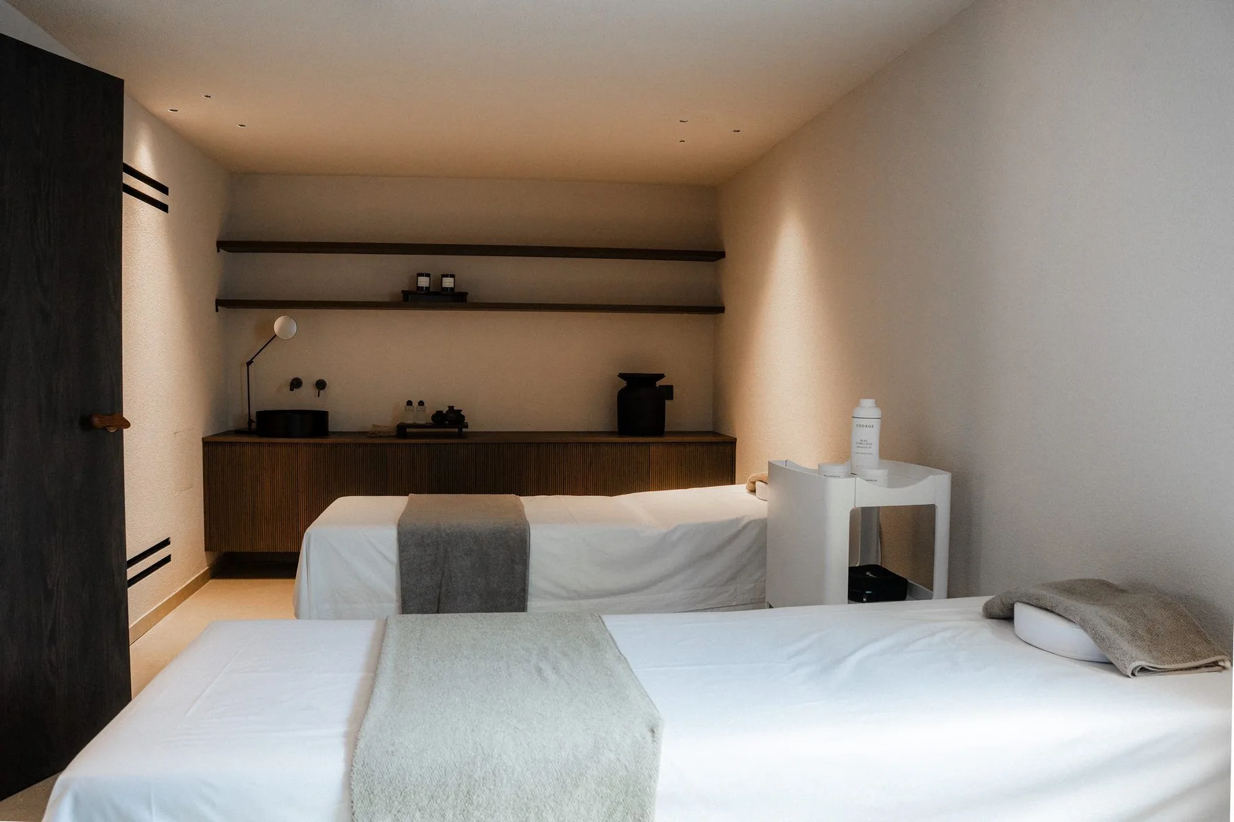 A bedroom with a bed and a long wooden counter along the back wall.