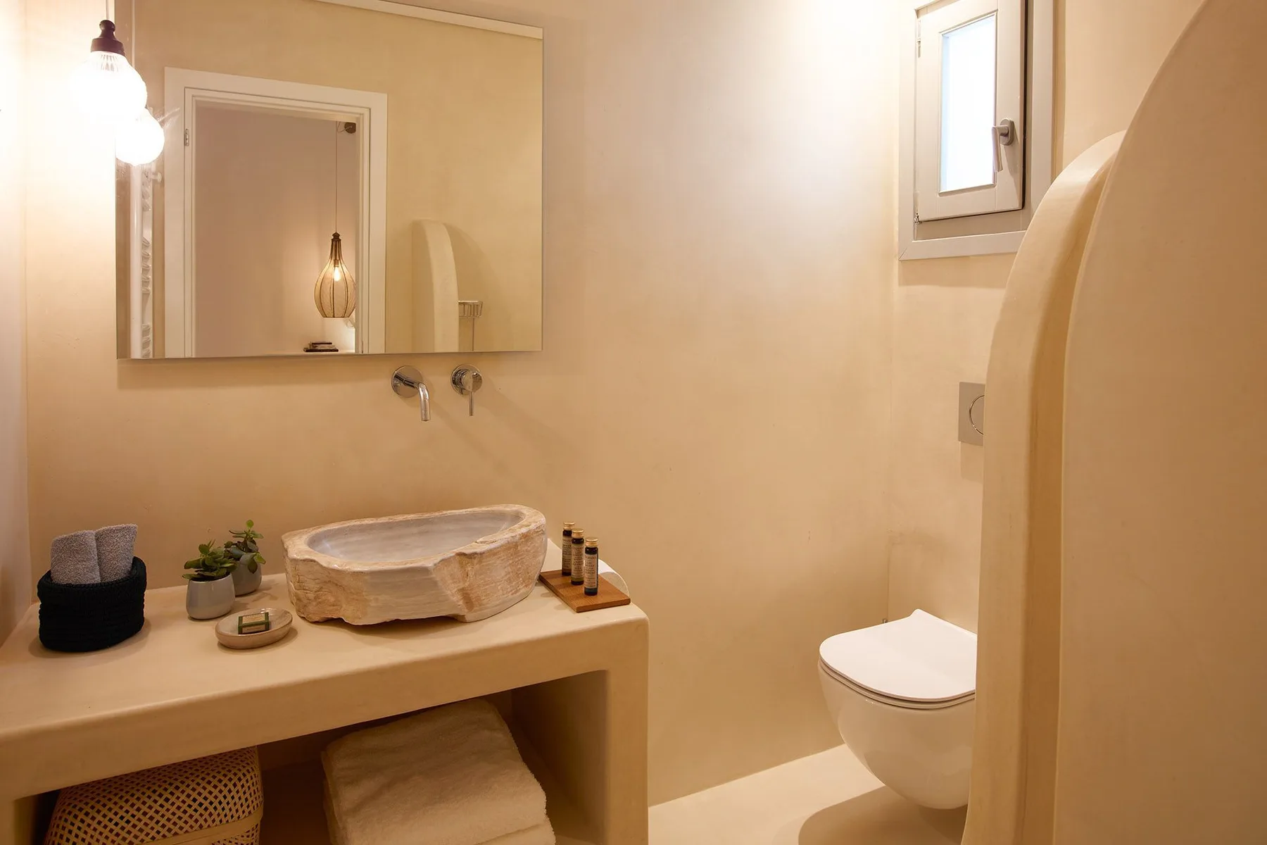 A bathroom with a sink vanity, mirror, and toilet.