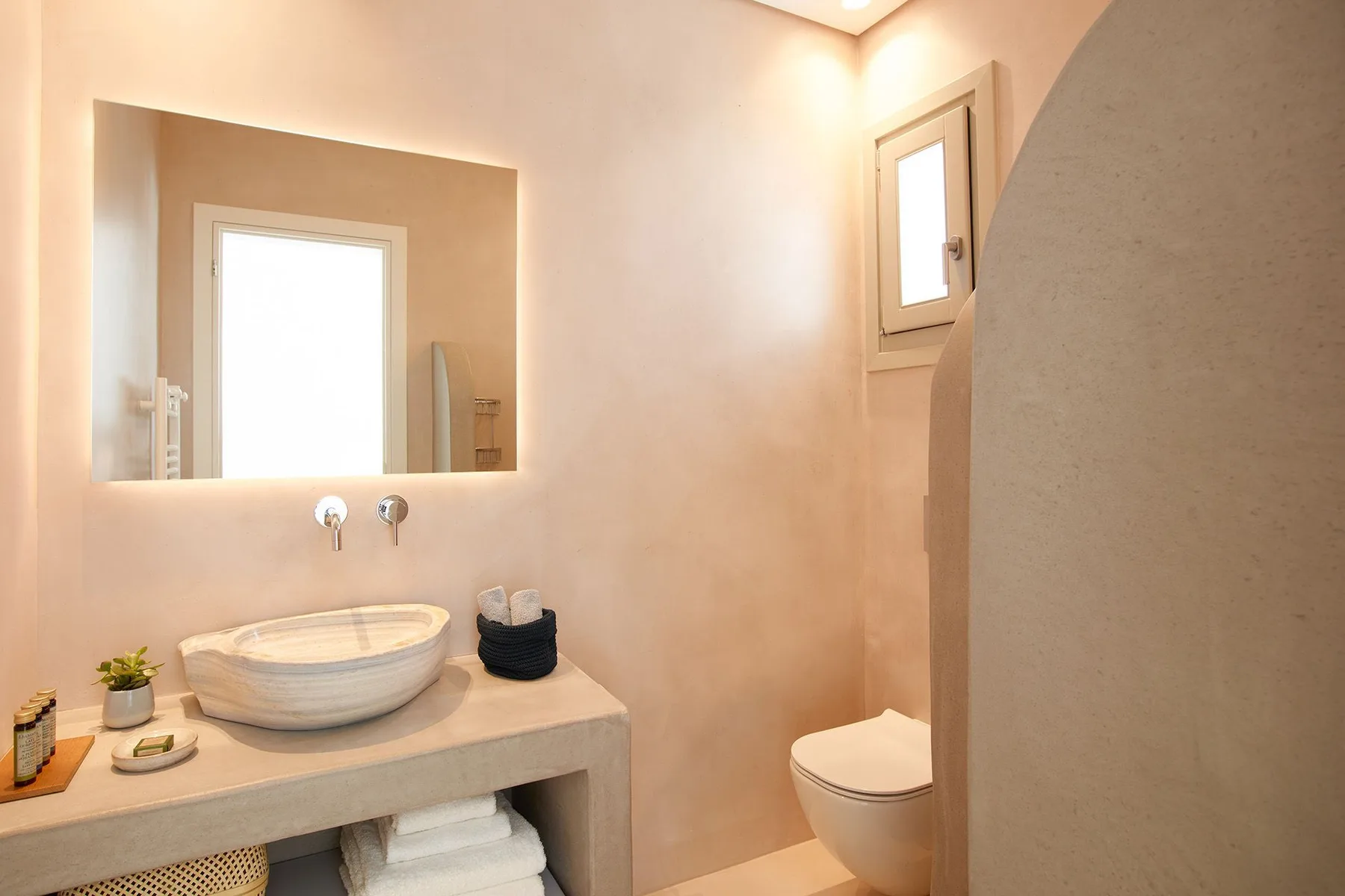 A bathroom with a vessel sink, a wall mirror, and a toilet.