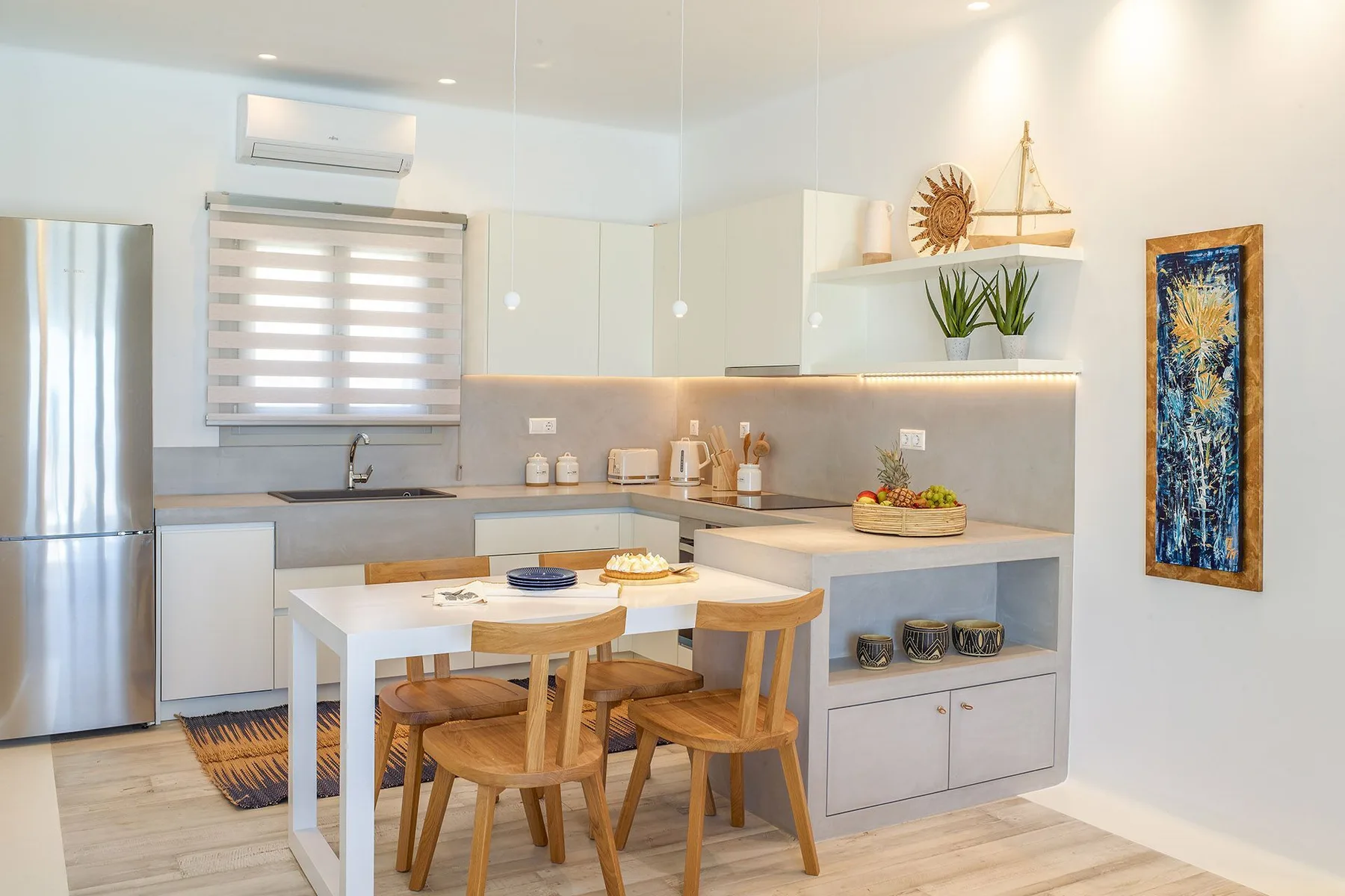 A bright kitchen with a dining table and wooden seating.