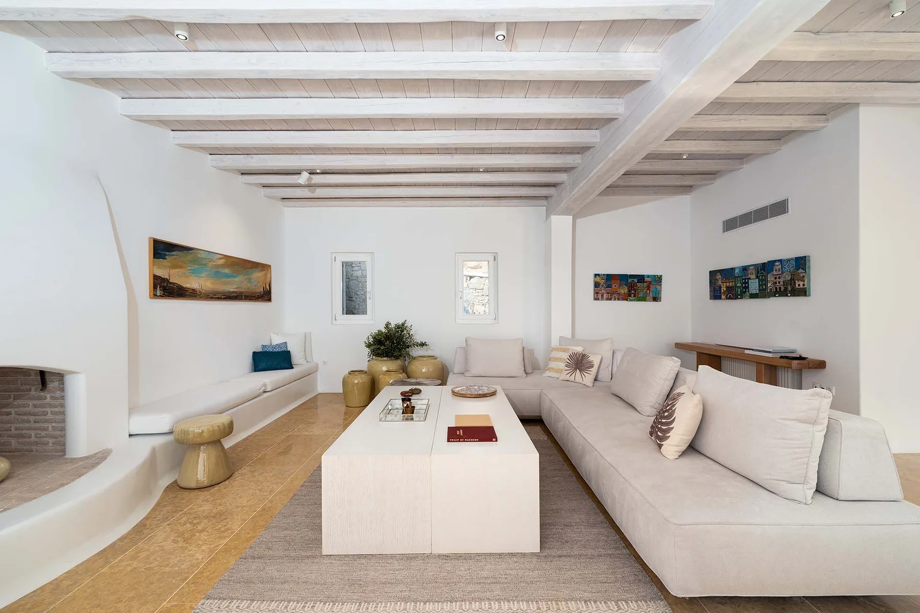 A bright living room with pale seating arranged around a low coffee table.