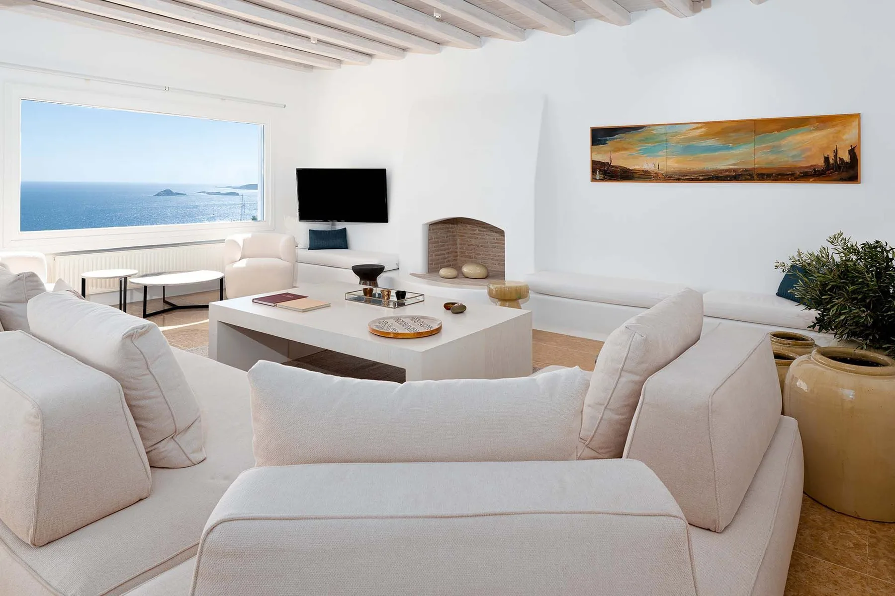 A bright living room with pale seating arranged around a low coffee table.